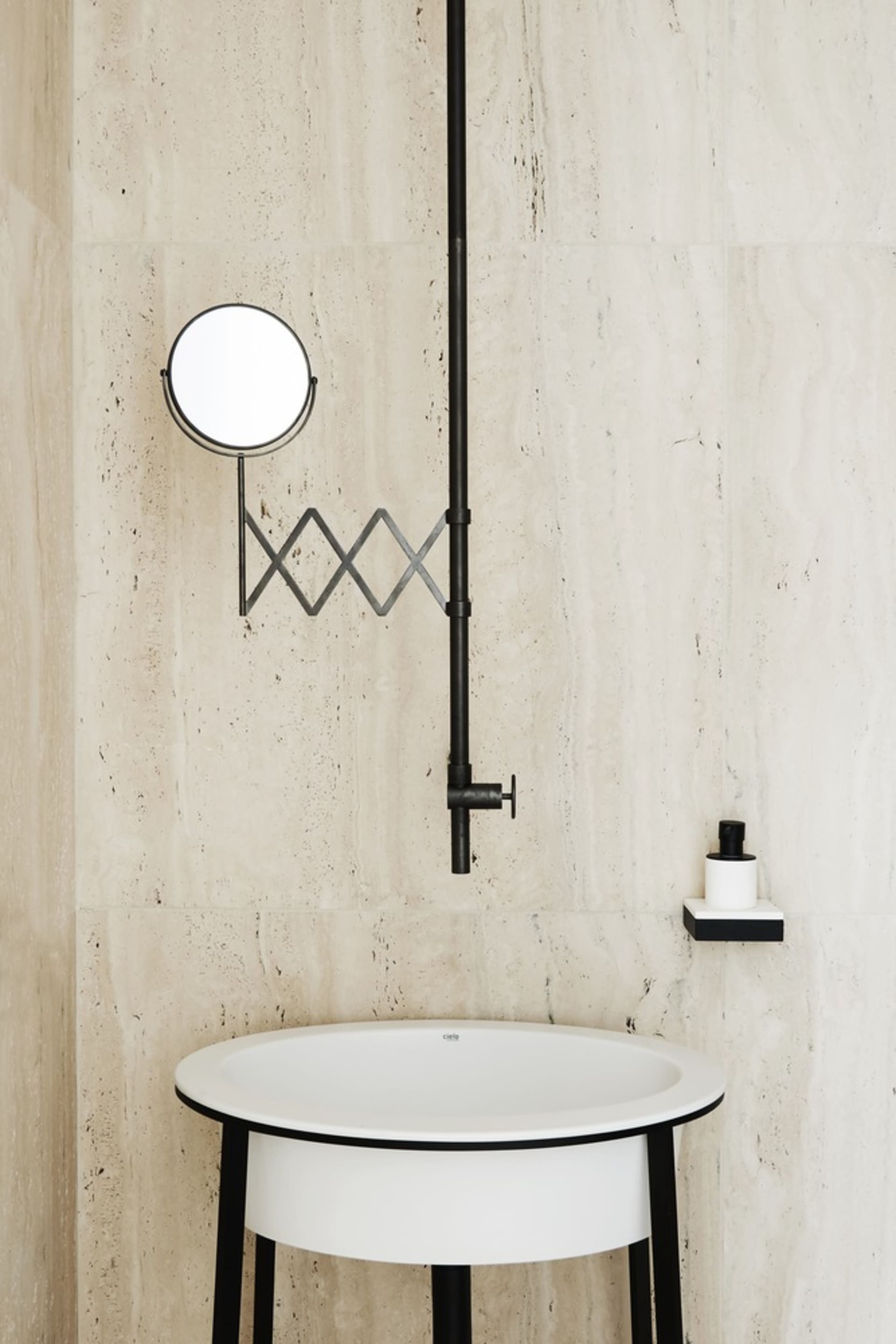 A modern bathroom with marble walls and a white sink.