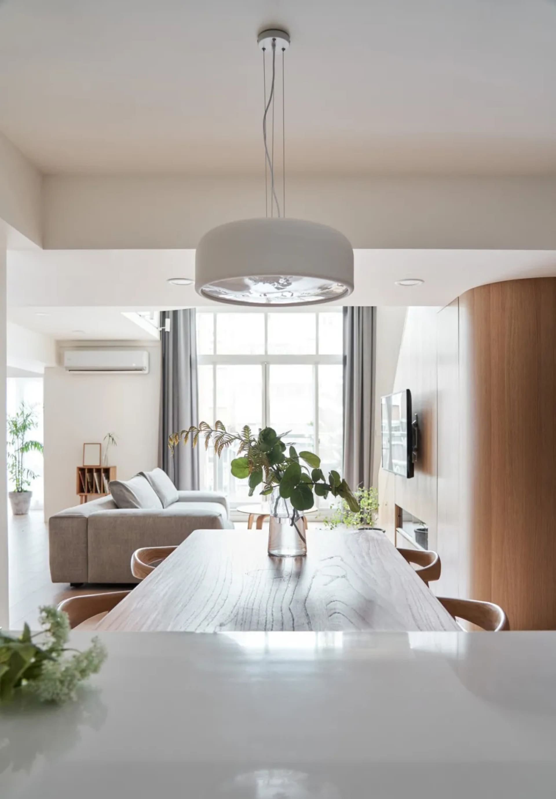 Modern living room with wooden elements and a large window.