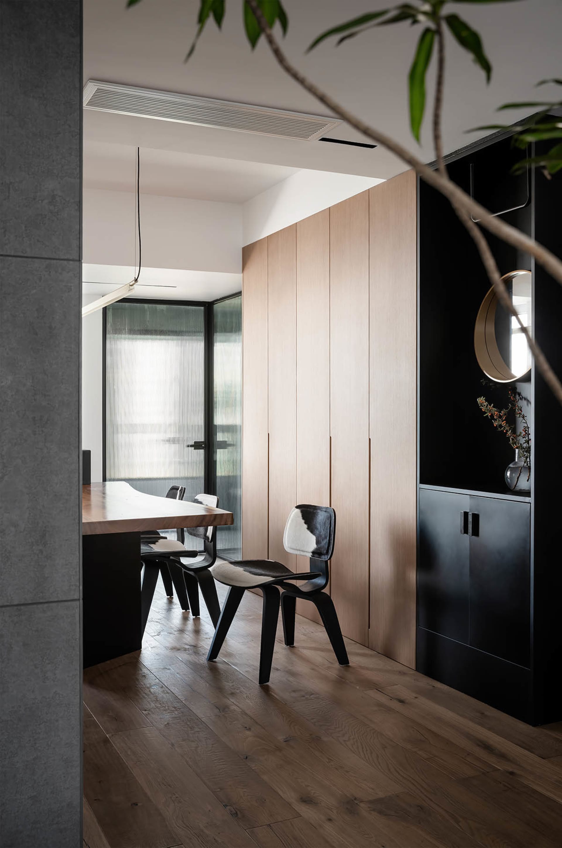 Modern dining room with wooden furniture and black and white chairs.