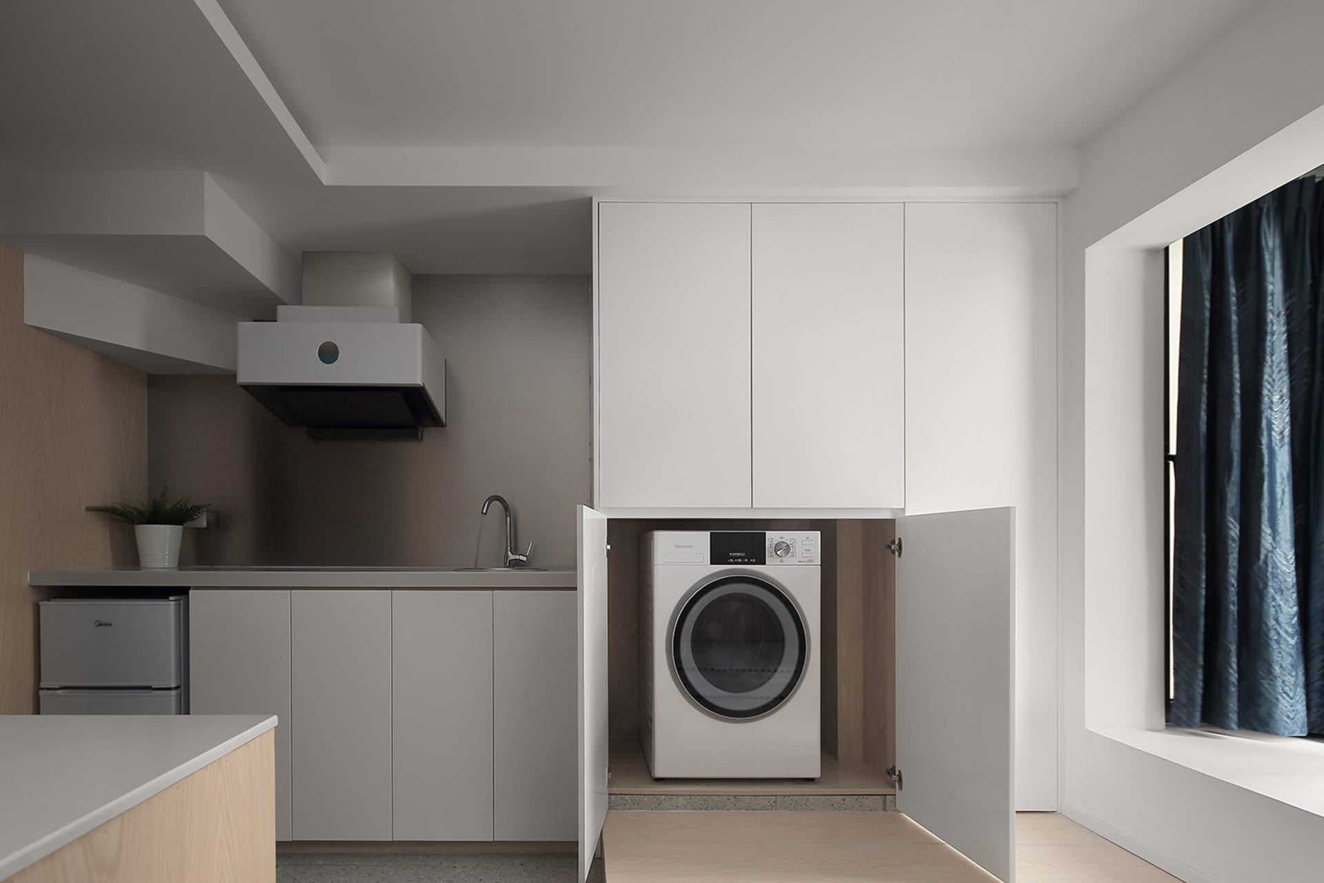 Modern kitchen with white cabinets, appliances, and floor.
