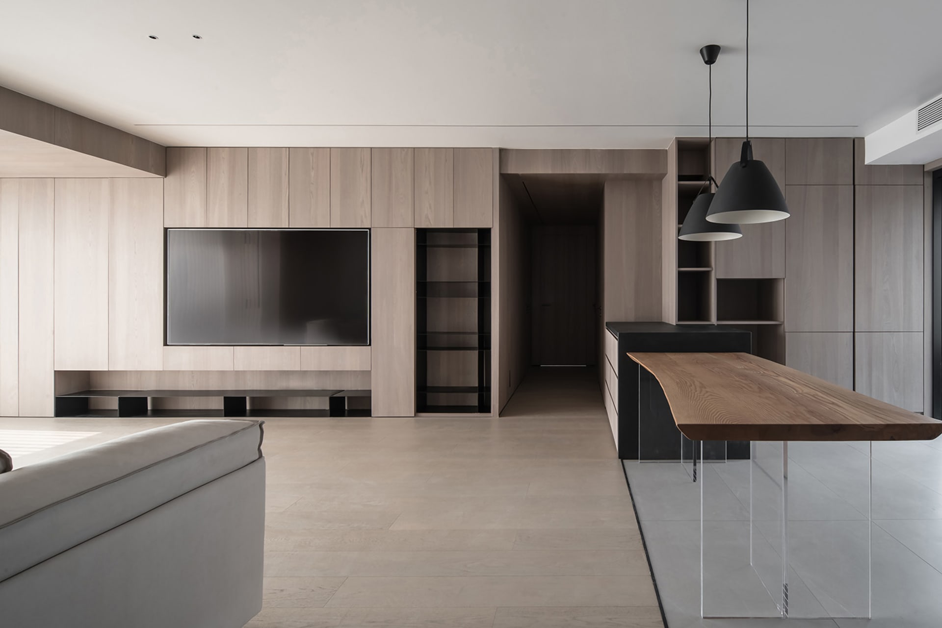 Modern minimalist kitchen with open-concept design, featuring wooden textured cabinets and concrete flooring.
