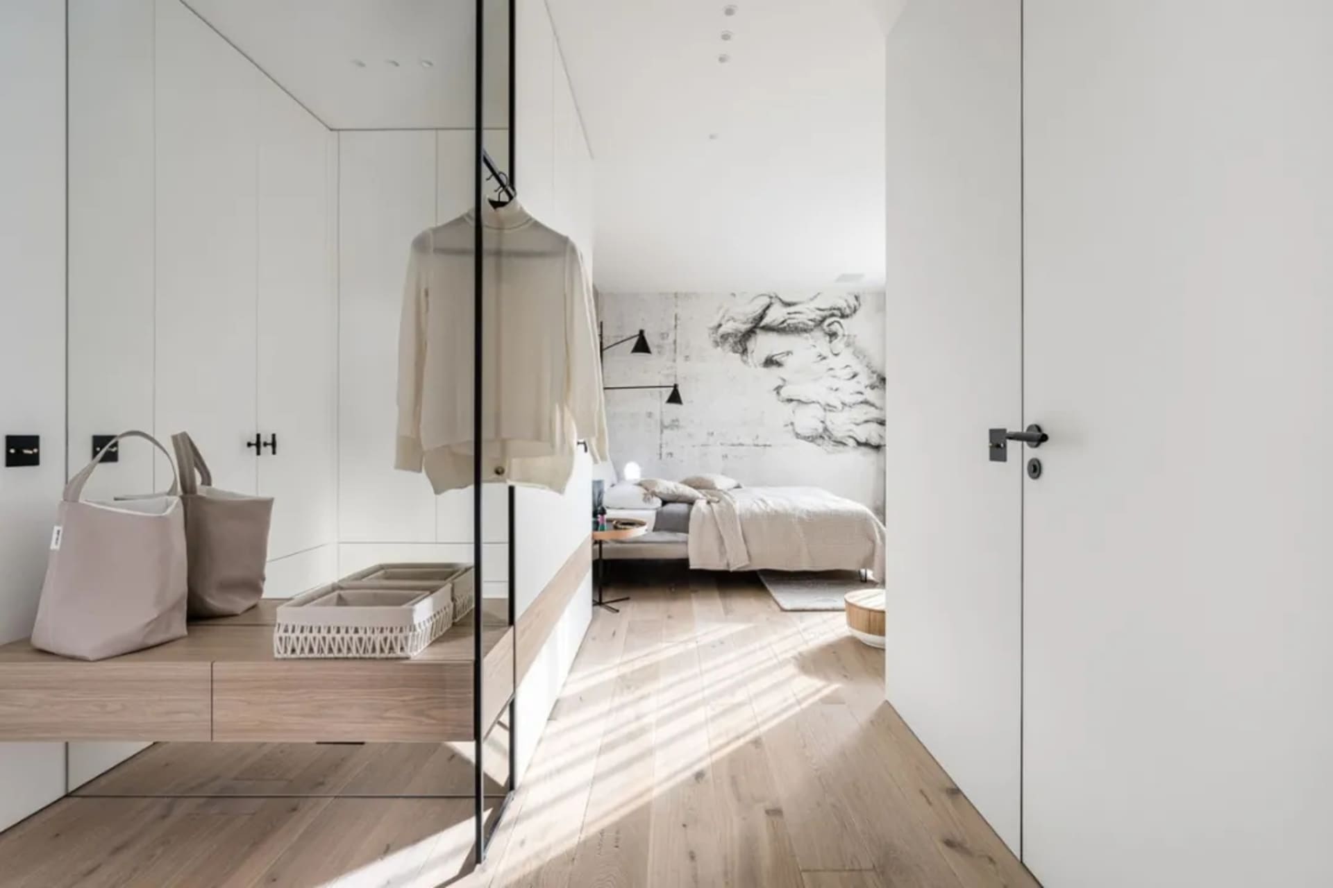Modern minimalist bedroom featuring concrete walls and hardwood flooring with soft furnishings.