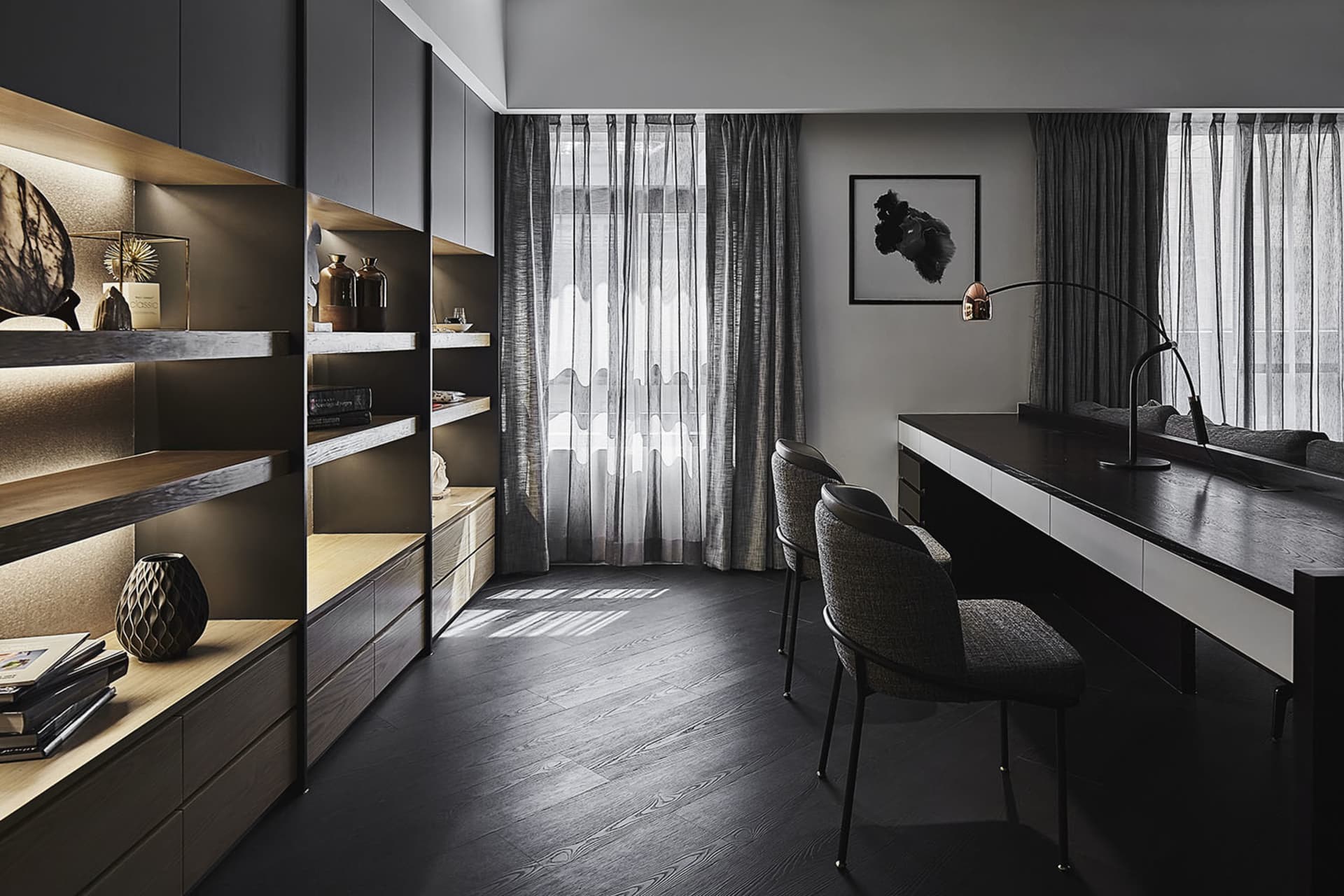 A modern office space featuring black metal and glass furniture, minimalist decor, and large windows with sheer curtains.