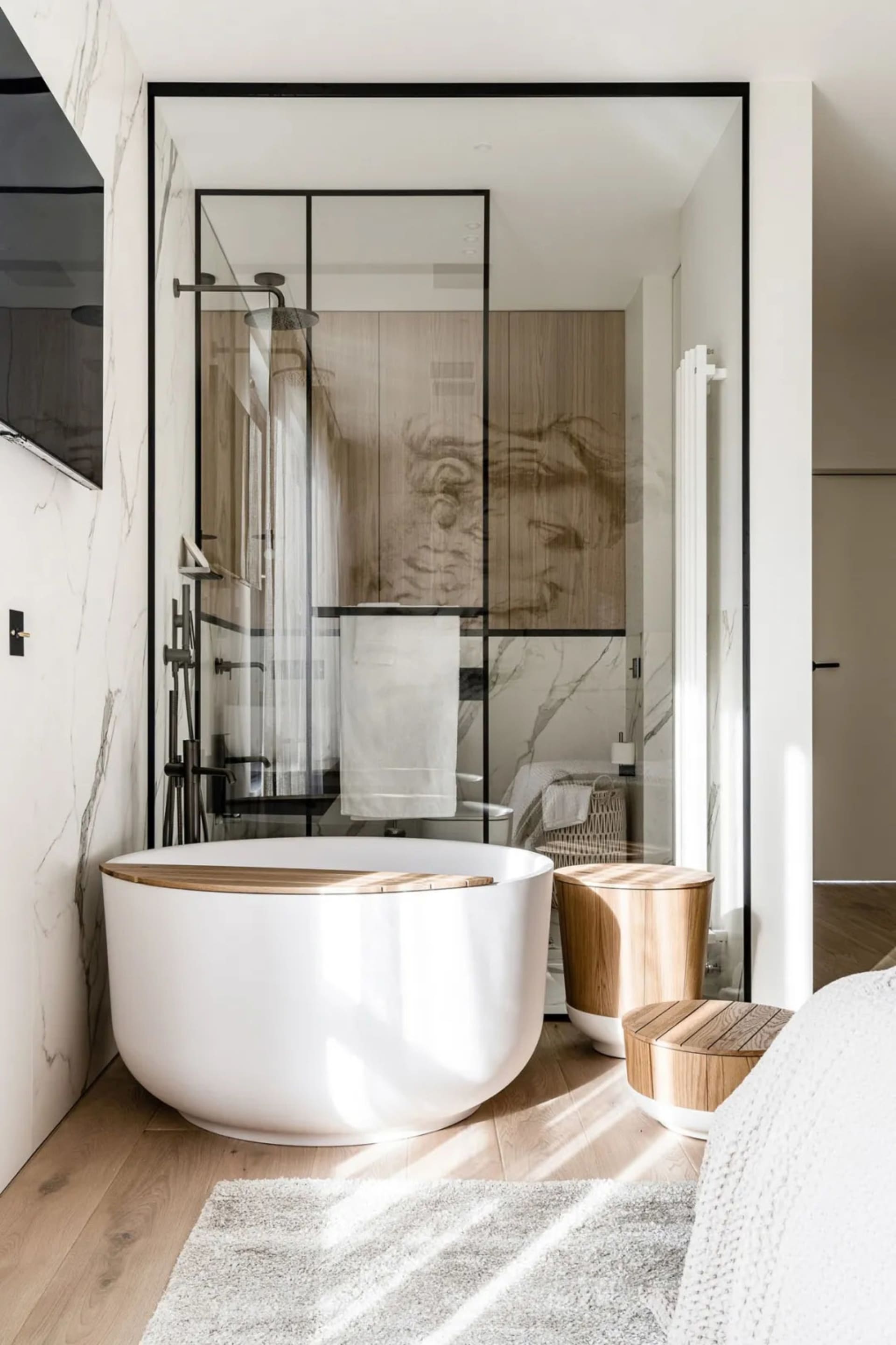 Modern minimalist bathroom with marble walls and a circular bathtub.
