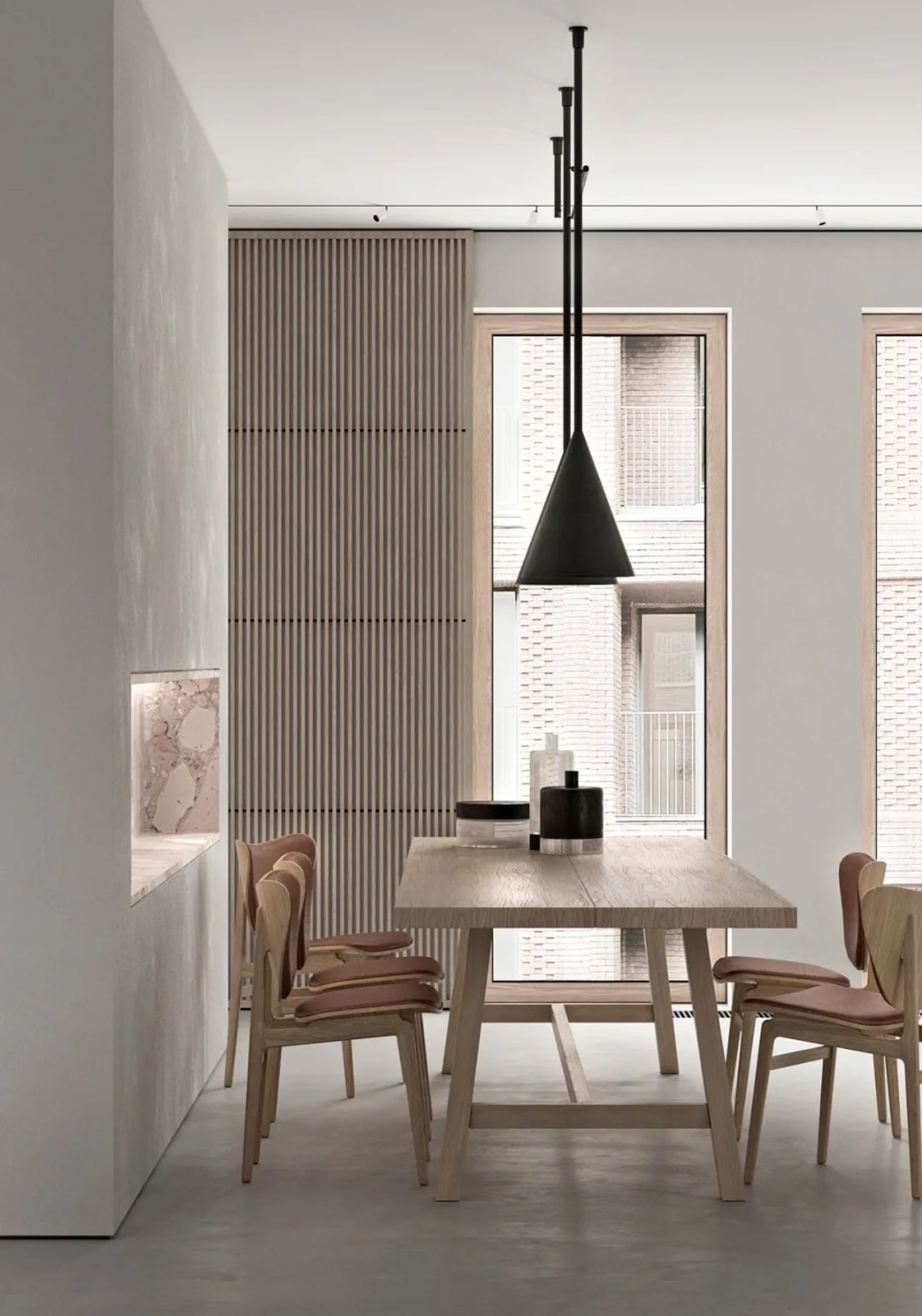 Modern dining room with minimalist design, featuring a wooden dining table, chairs, and pendant light against a concrete wall