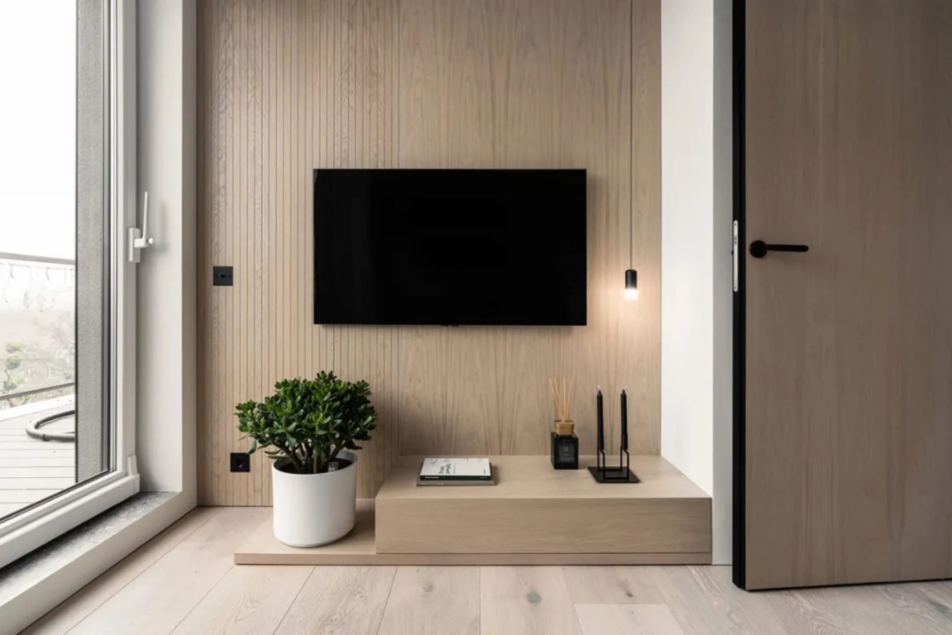 A modern minimalist living room featuring a bench constructed of wood, with a flat-screen TV mounted on a wooden wall and a p