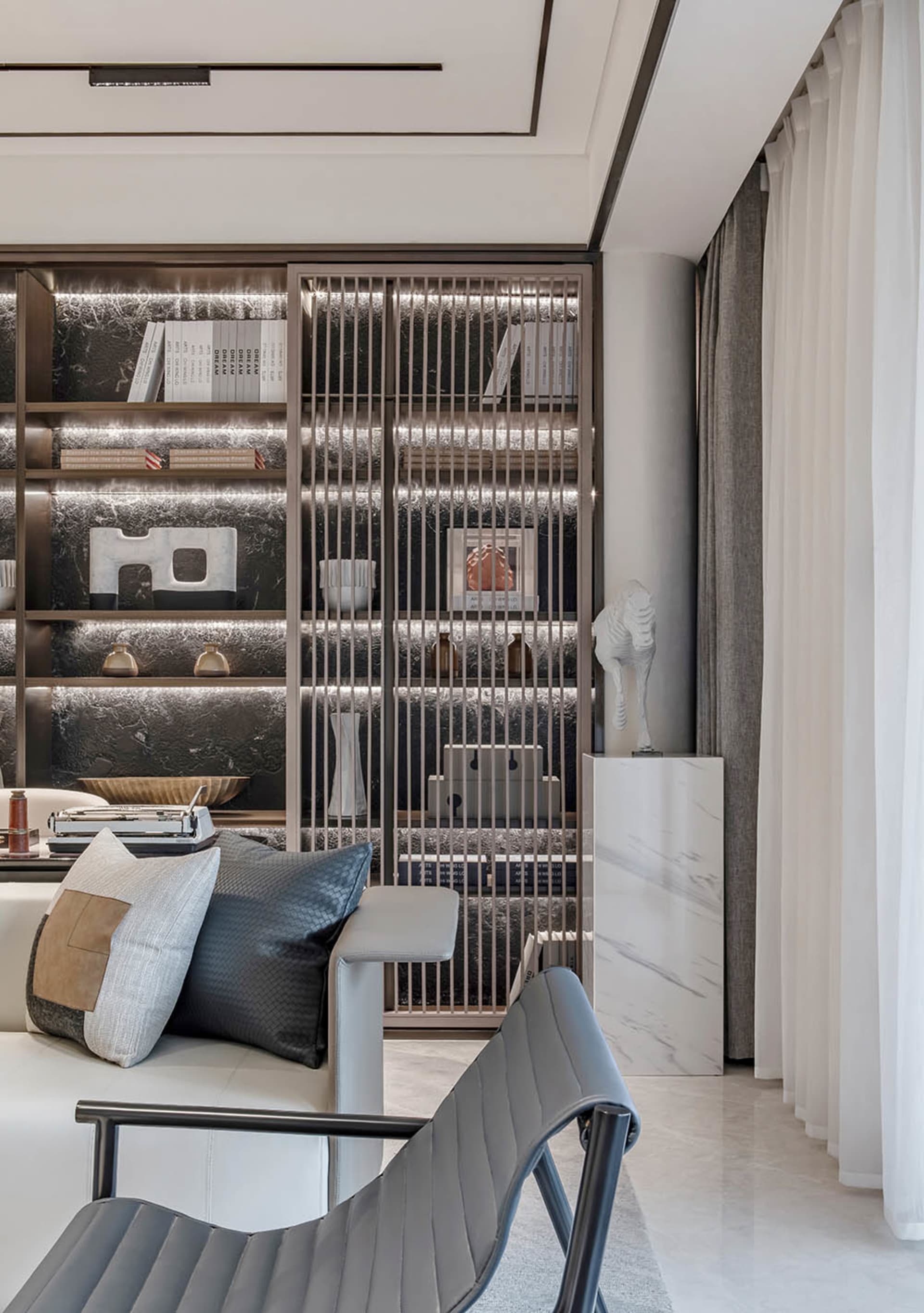 Modern living room featuring metal bookshelves, marble accents, and fabric seating.