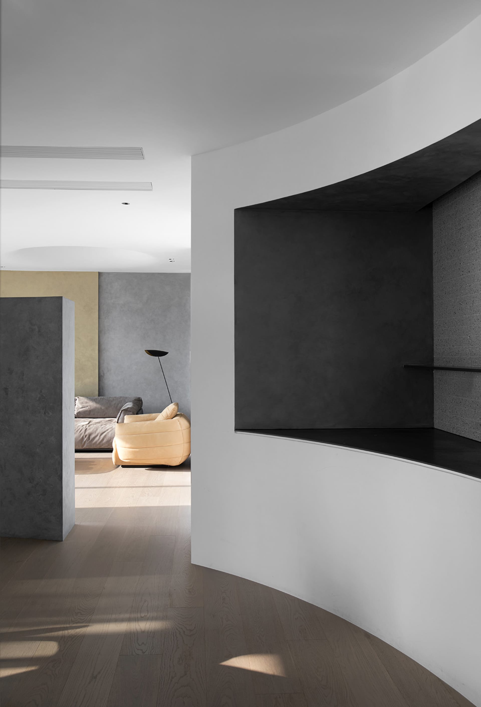 Modern living room featuring a wooden floor and concrete walls.