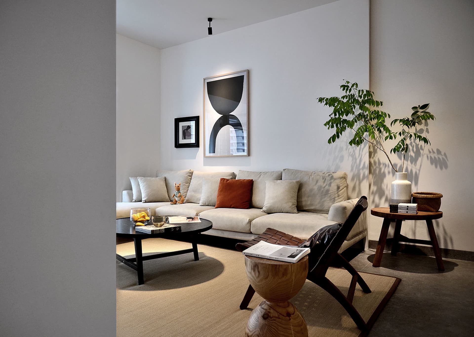 A minimalist living room with neutral-toned furniture and concrete elements.