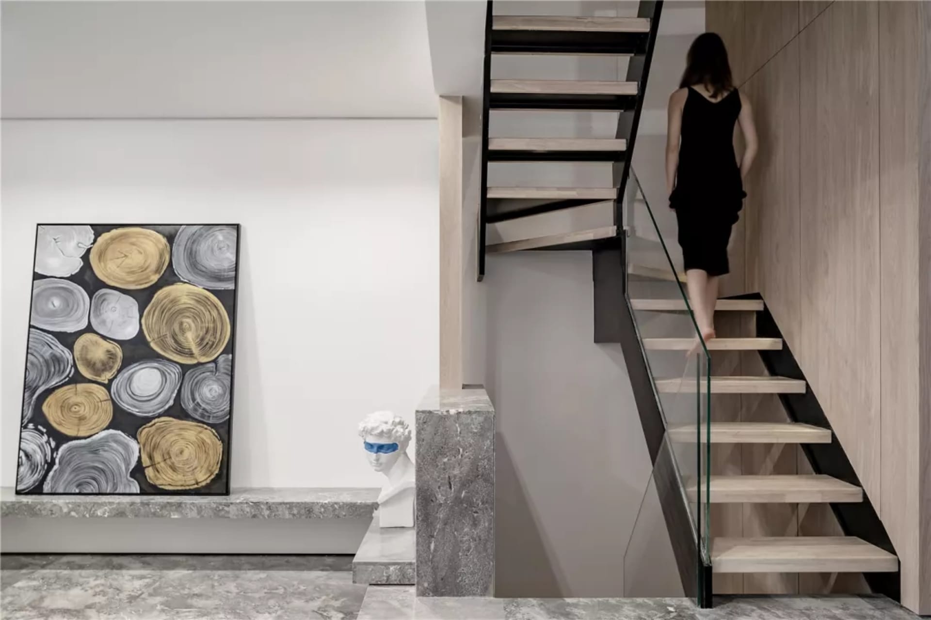 A modern interior design featuring glass, concrete, and wooden elements.