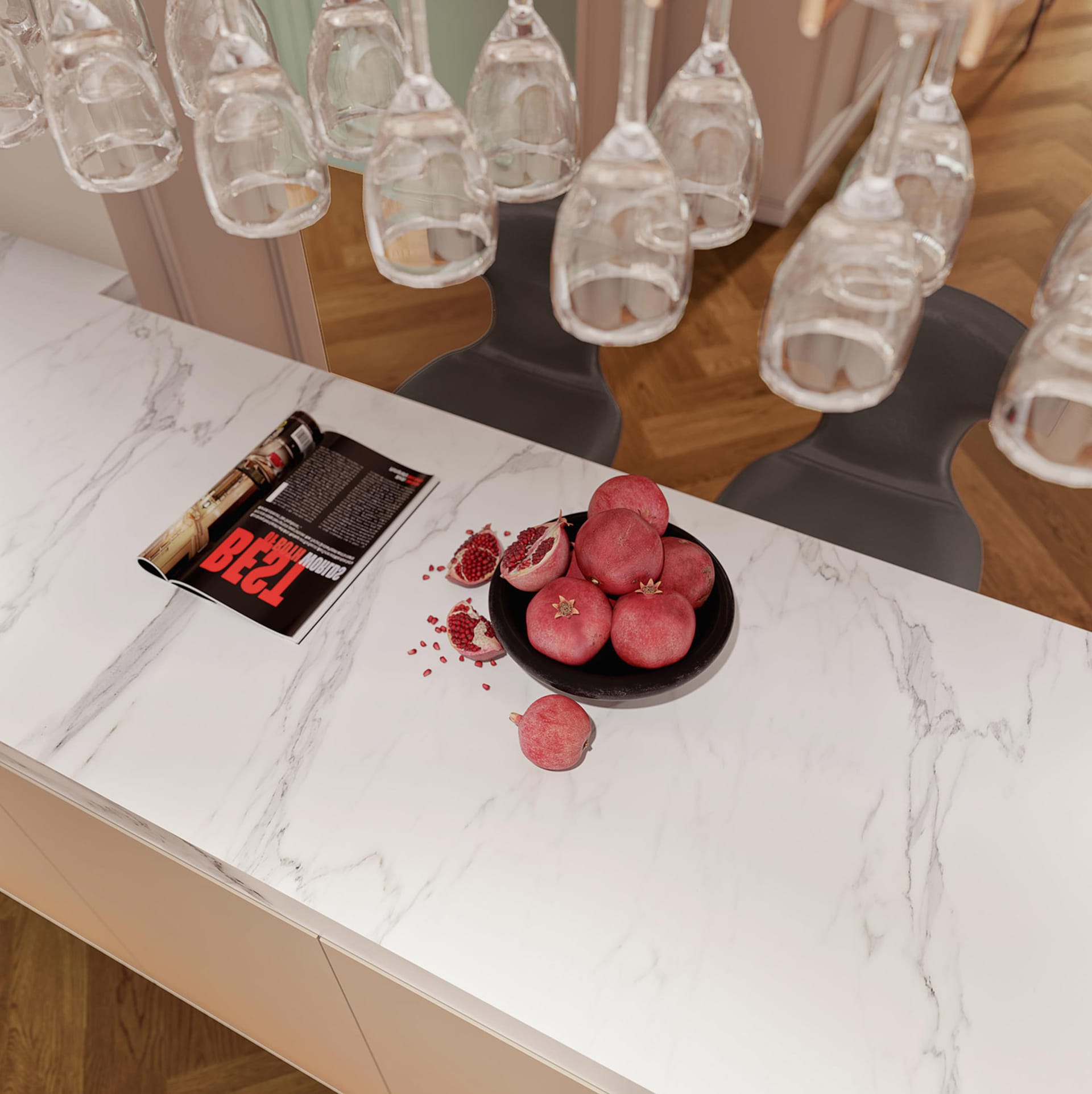 Top view of a modern kitchen interior with marble countertop, fresh pomegranates, and wine glasses hanging above.
