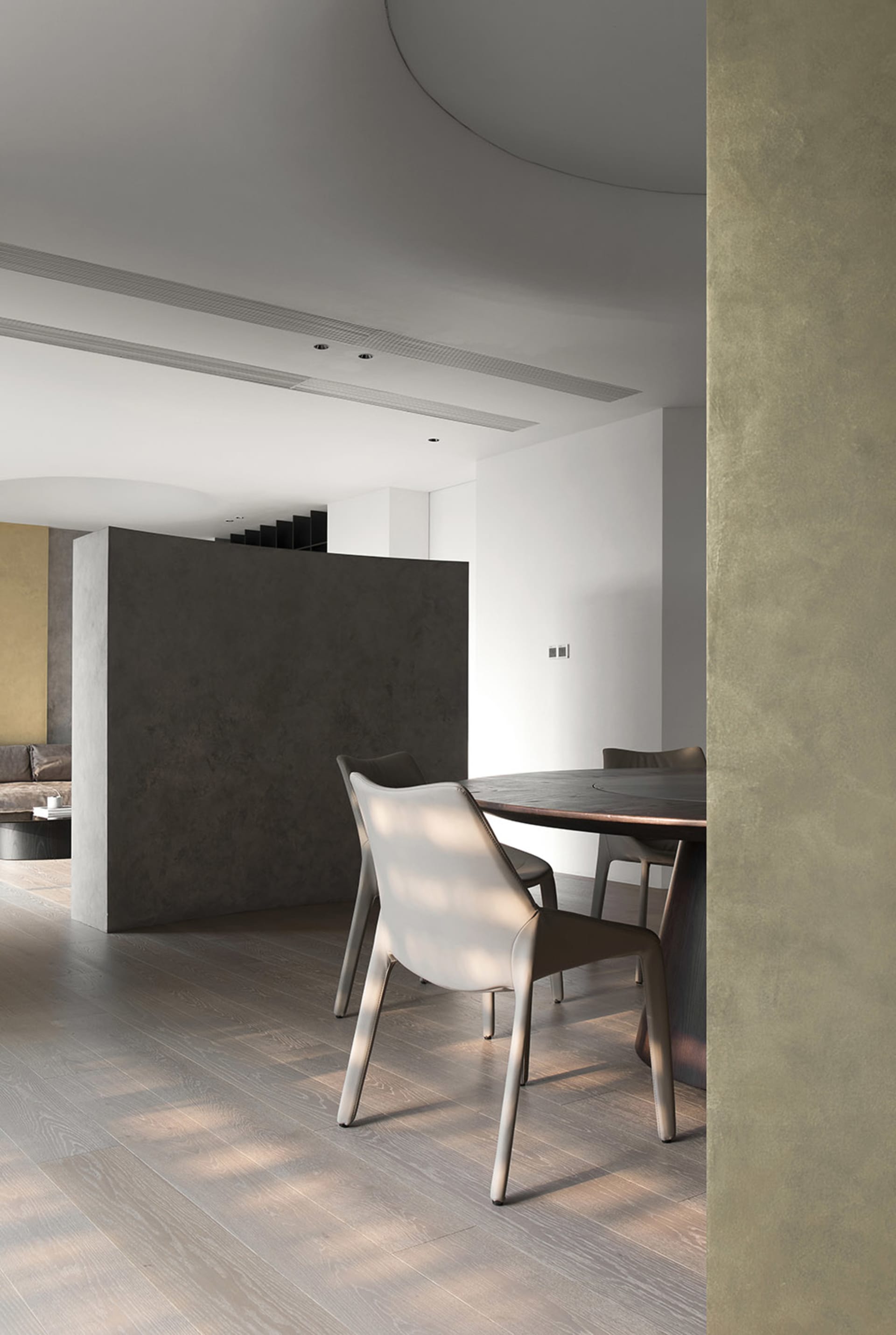A modern living room with concrete walls, a wooden floor, and metal accents.