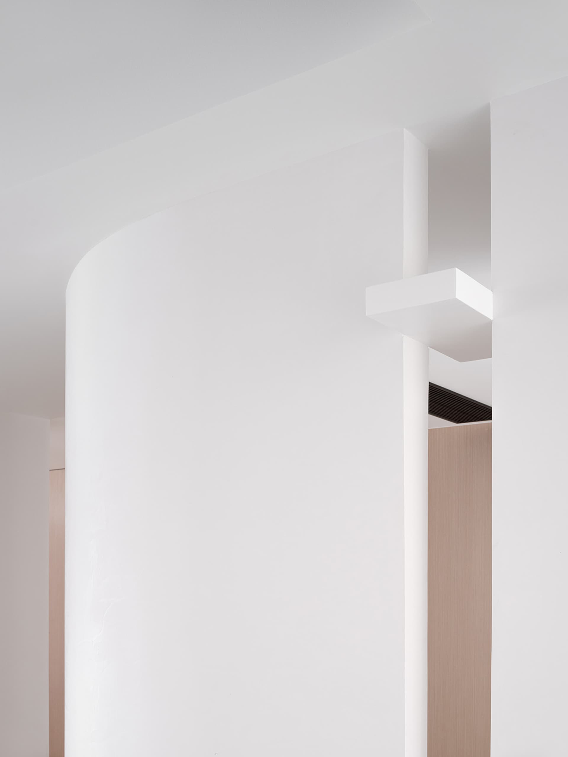 Minimalist office space featuring white-painted walls and concrete columns.