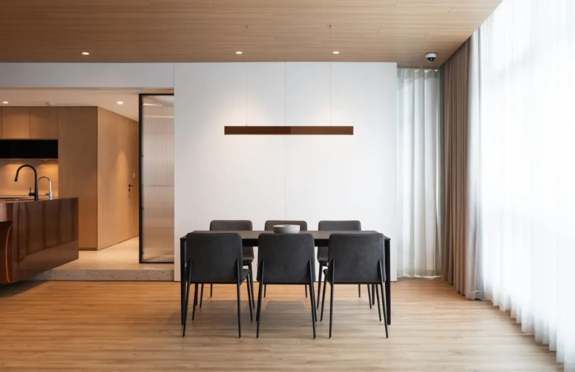 Modern living room with hardwood flooring and minimalist furniture.