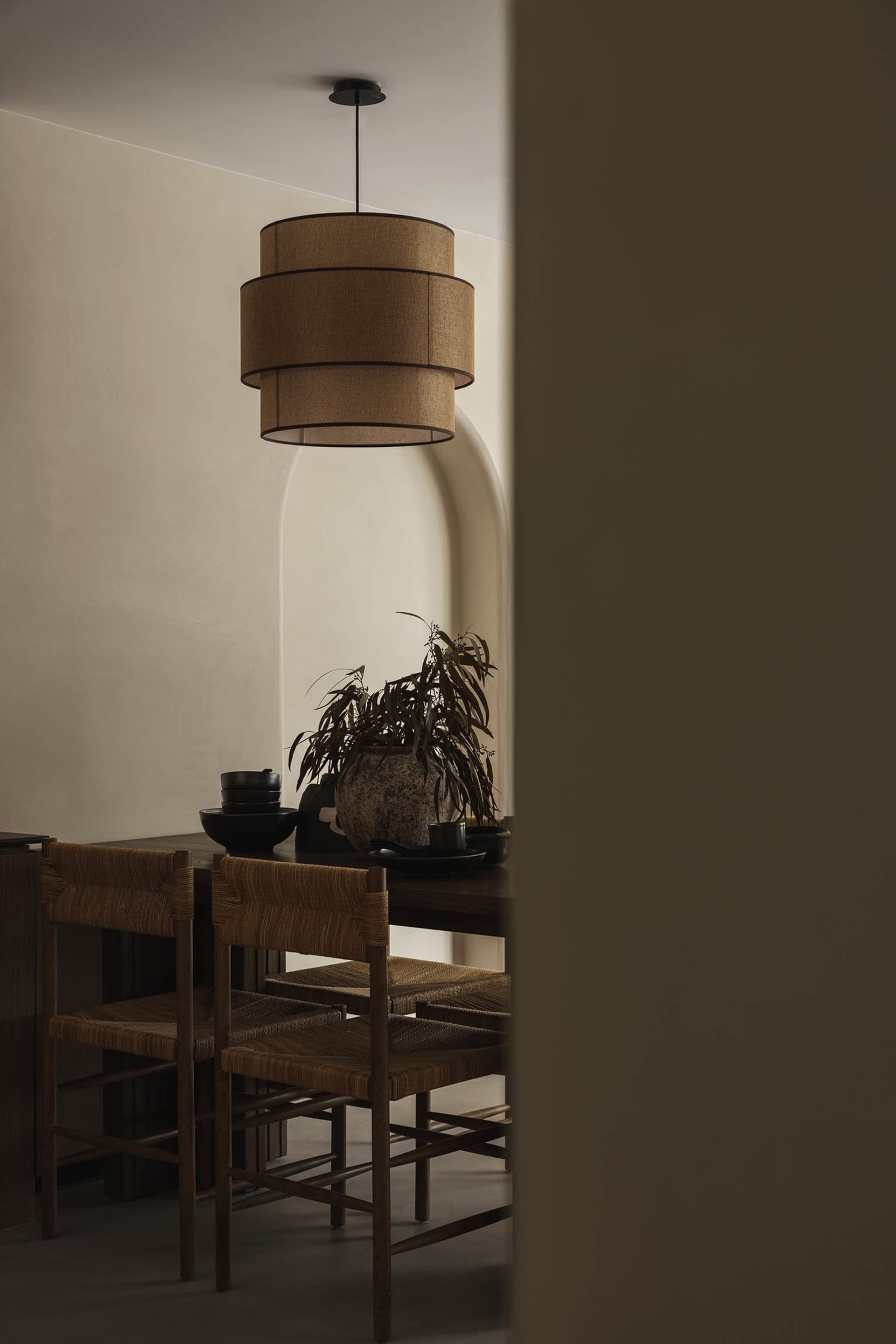Dining room featuring wooden furniture, with a layered chandelier hanging over the table.