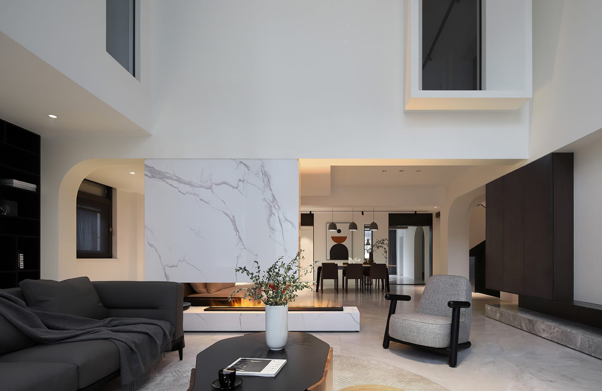 A sleek, modern living room with marble accents and a fireplace.