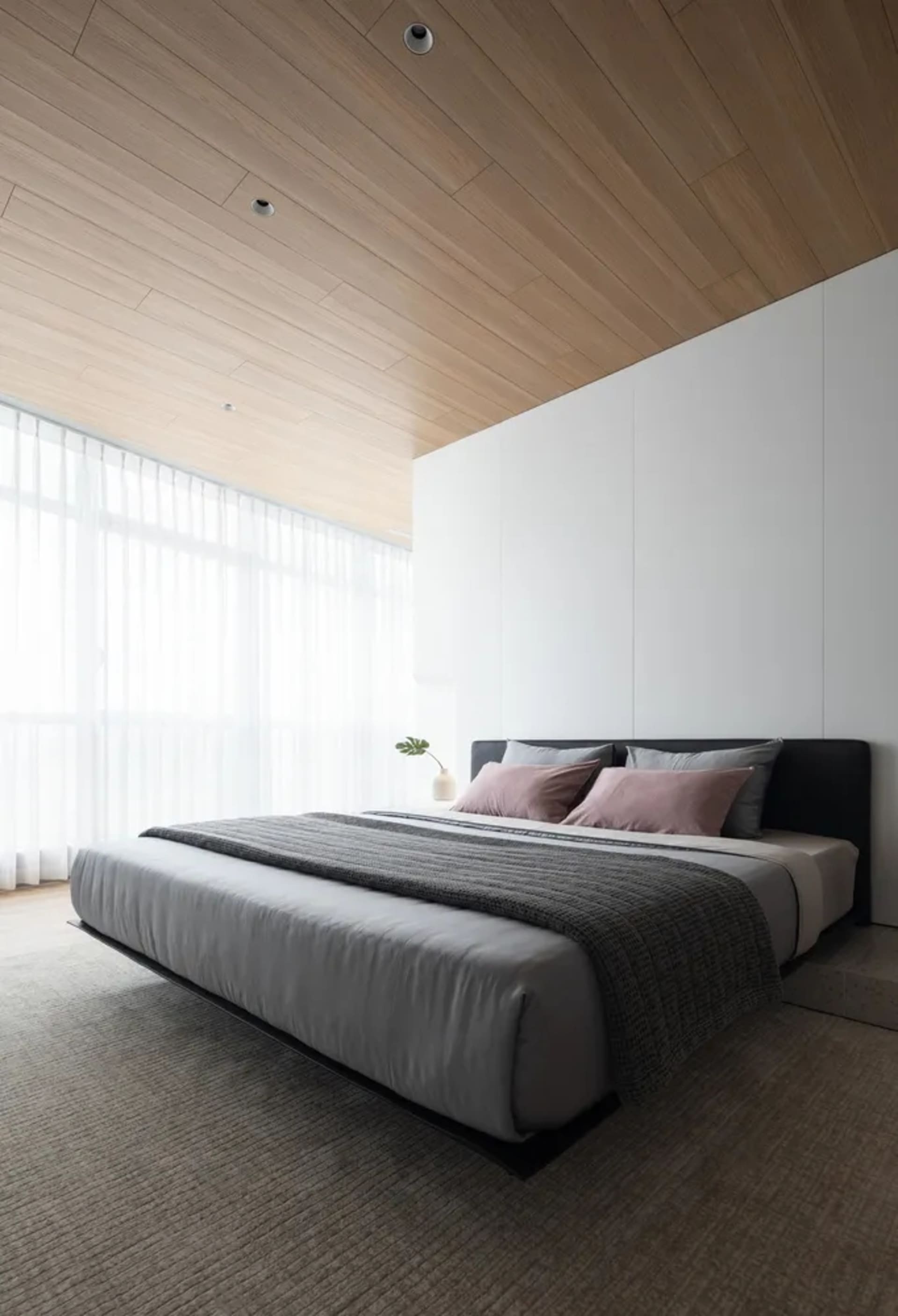 A modern minimalist bedroom with a wooden ceiling, gray bedding, and white walls.