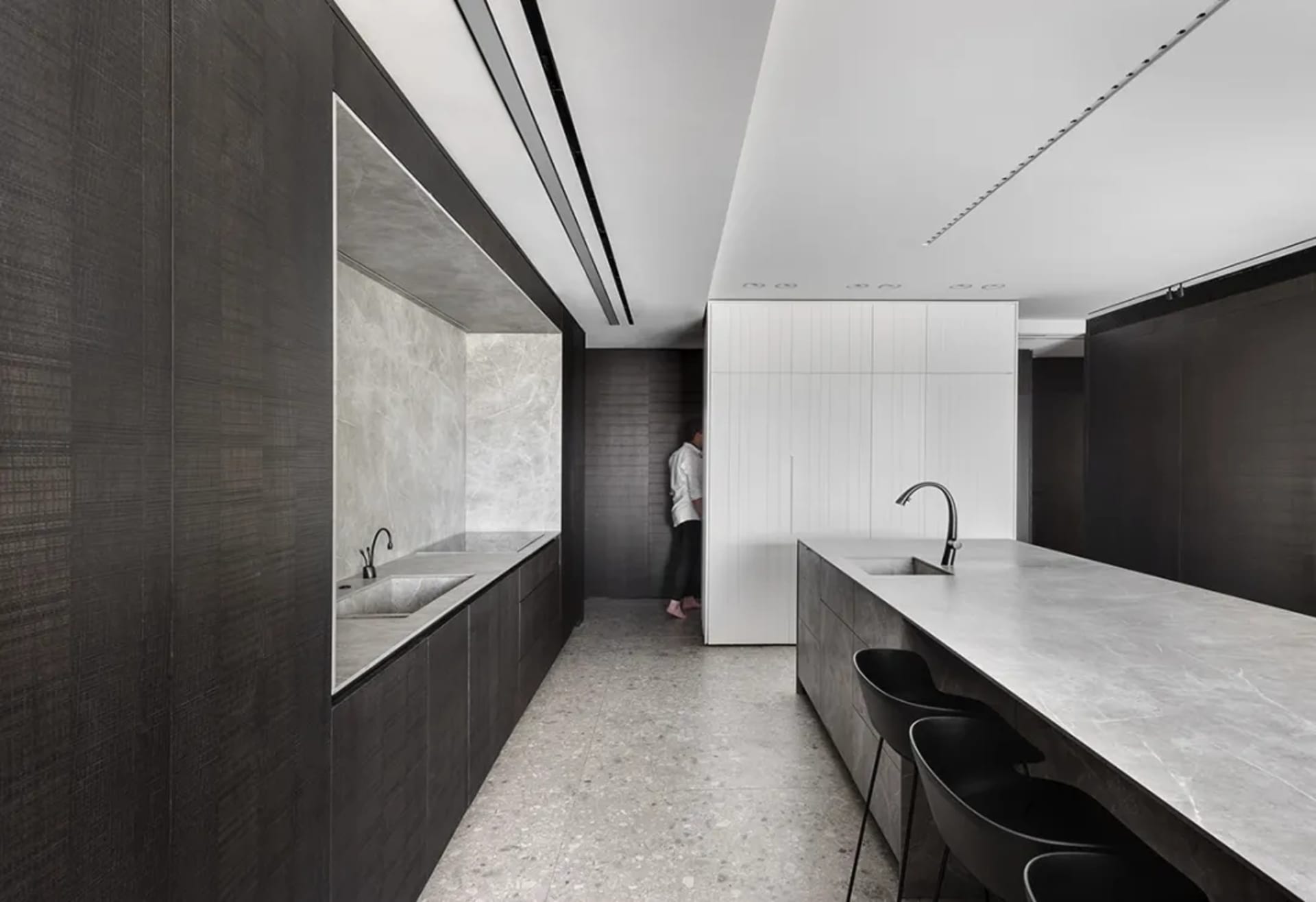Modern minimalist kitchen featuring marble countertops and walls