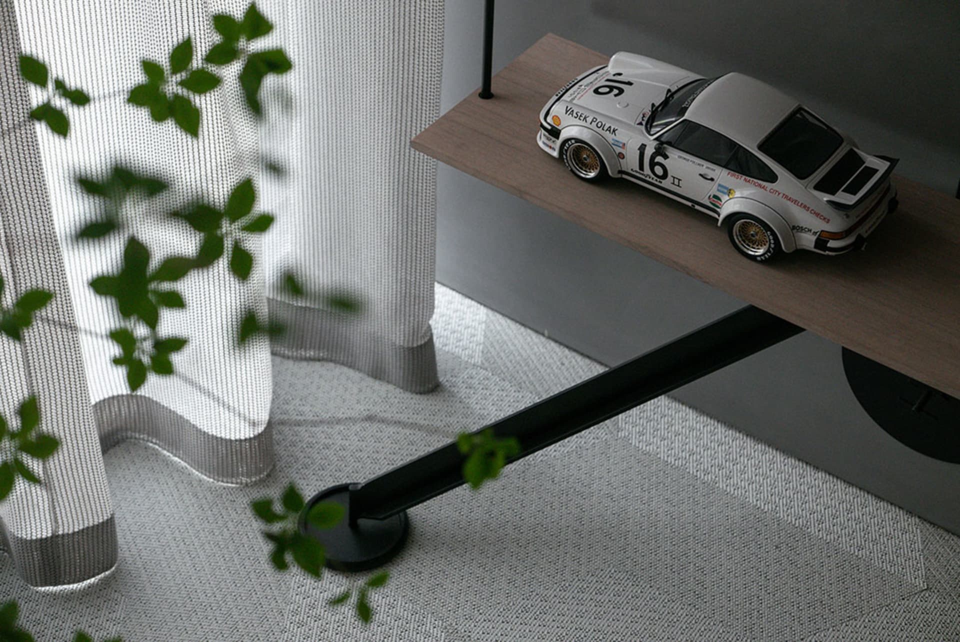 極簡風格的白色賽車模型展示於木質層架上。