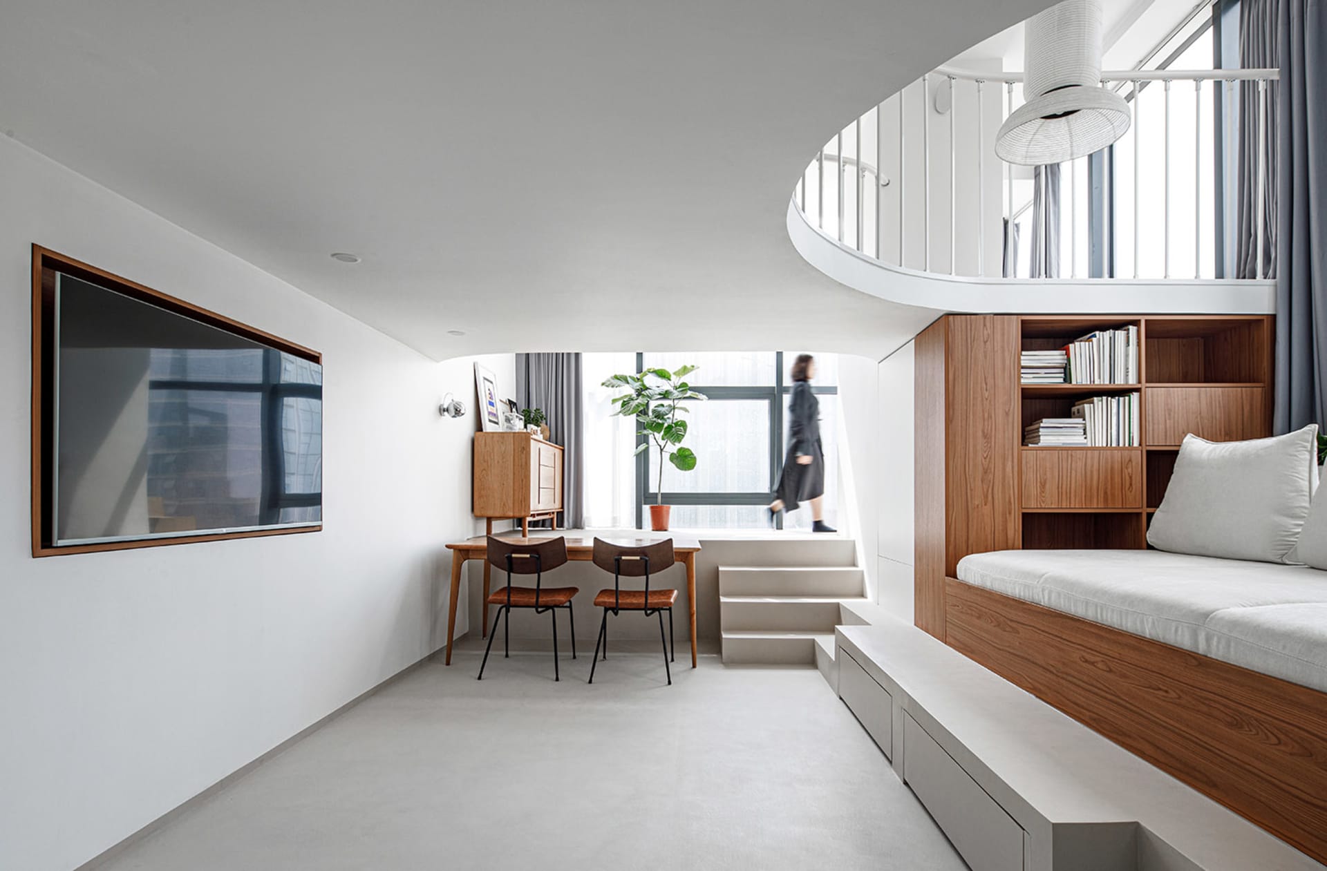 A modern apartment living room with a wooden bench, concrete floor, glass window, and white walls.