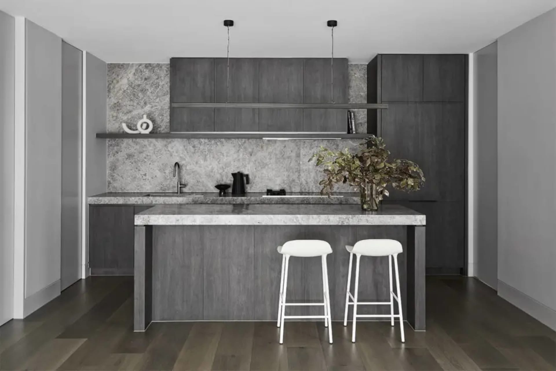 Modern kitchen with marble counter and dark wooden cabinets