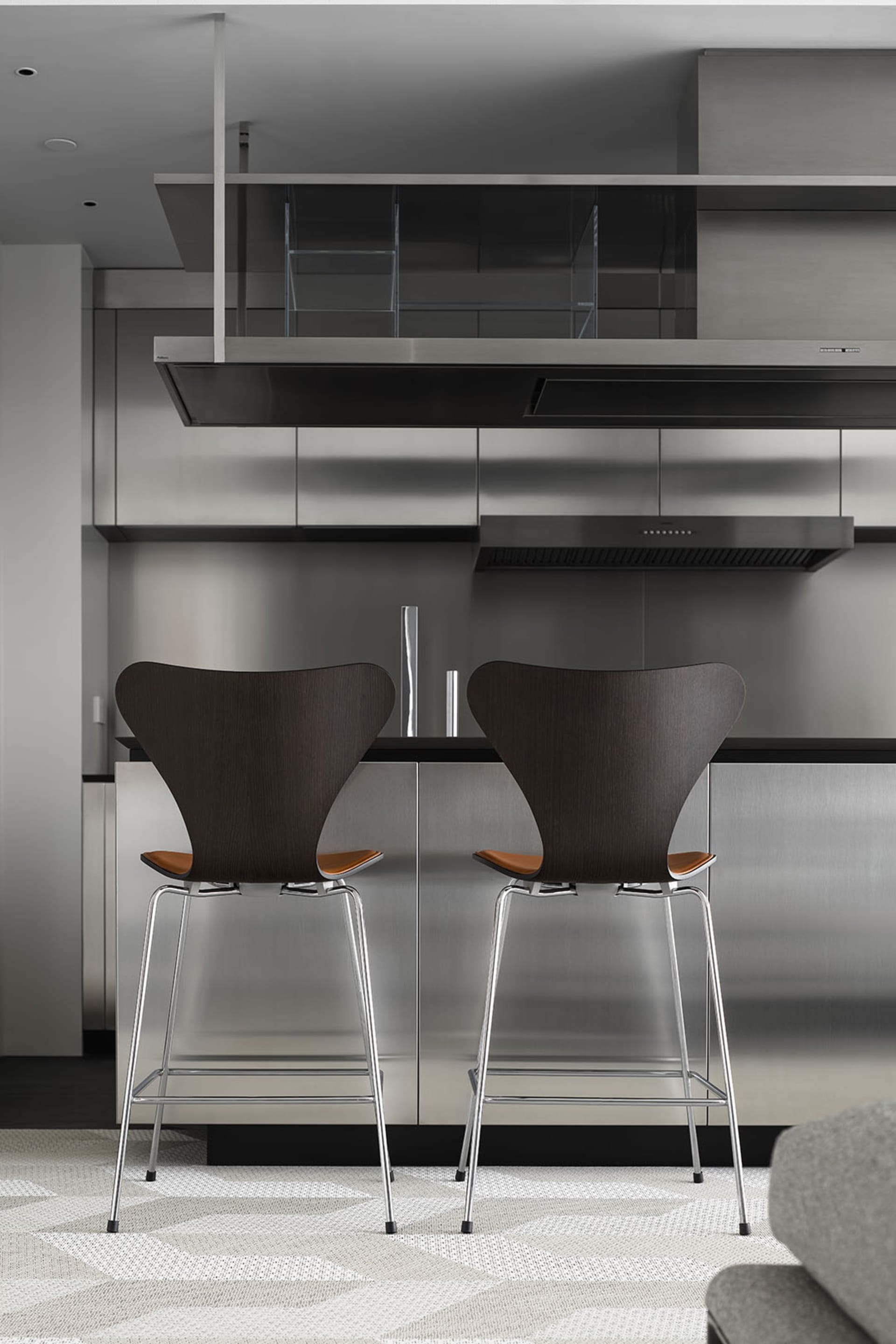 Modern industrial style kitchen with metal appliances and countertops.