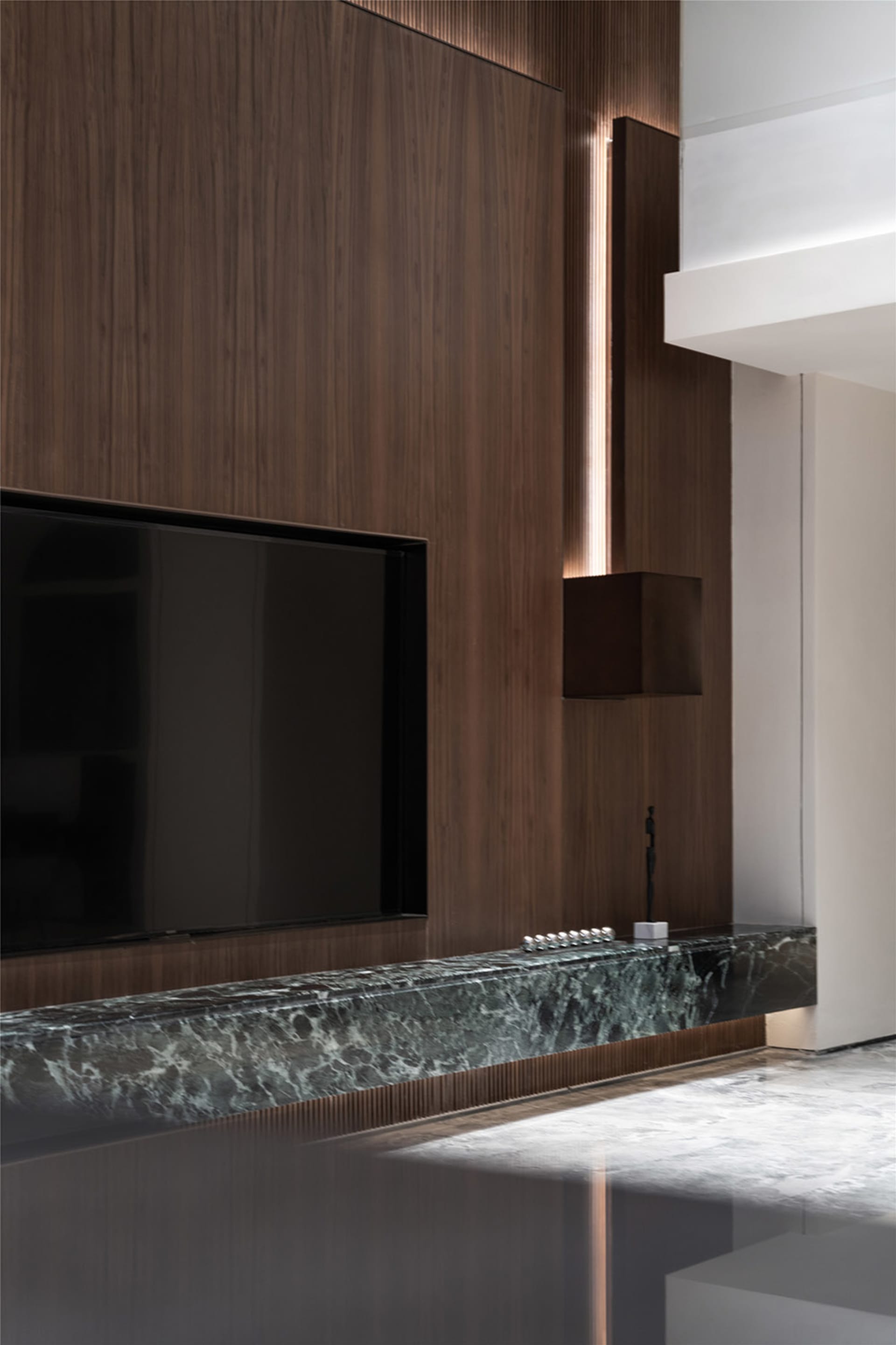 A modern interior space featuring wooden panels, leather furniture, and marble countertops.