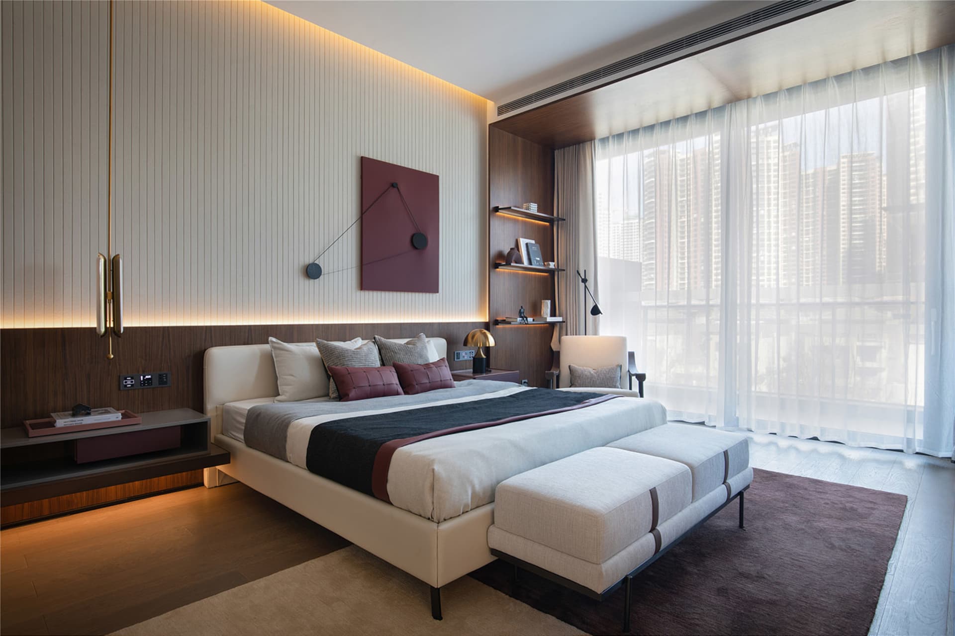 A modern minimalist bedroom with a white bed, wooden floor, and large window overlooking city buildings.