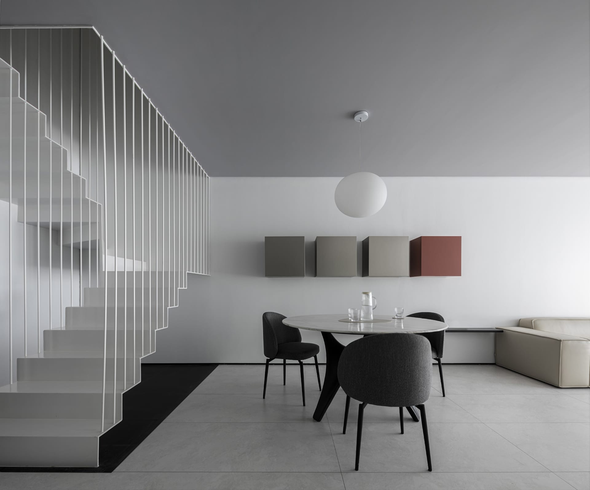 A minimalist modern dining room featuring sleek, black chairs and a white marble table with a black base.