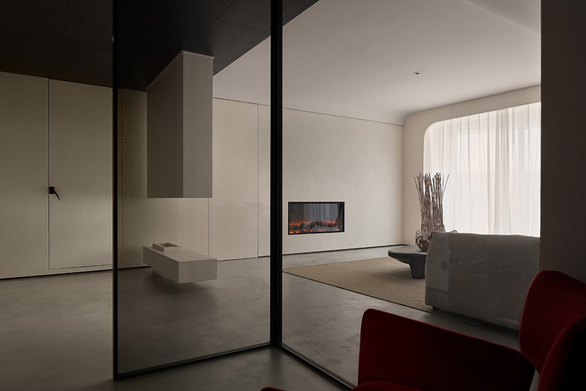 A modern living room featuring concrete walls and glass elements.