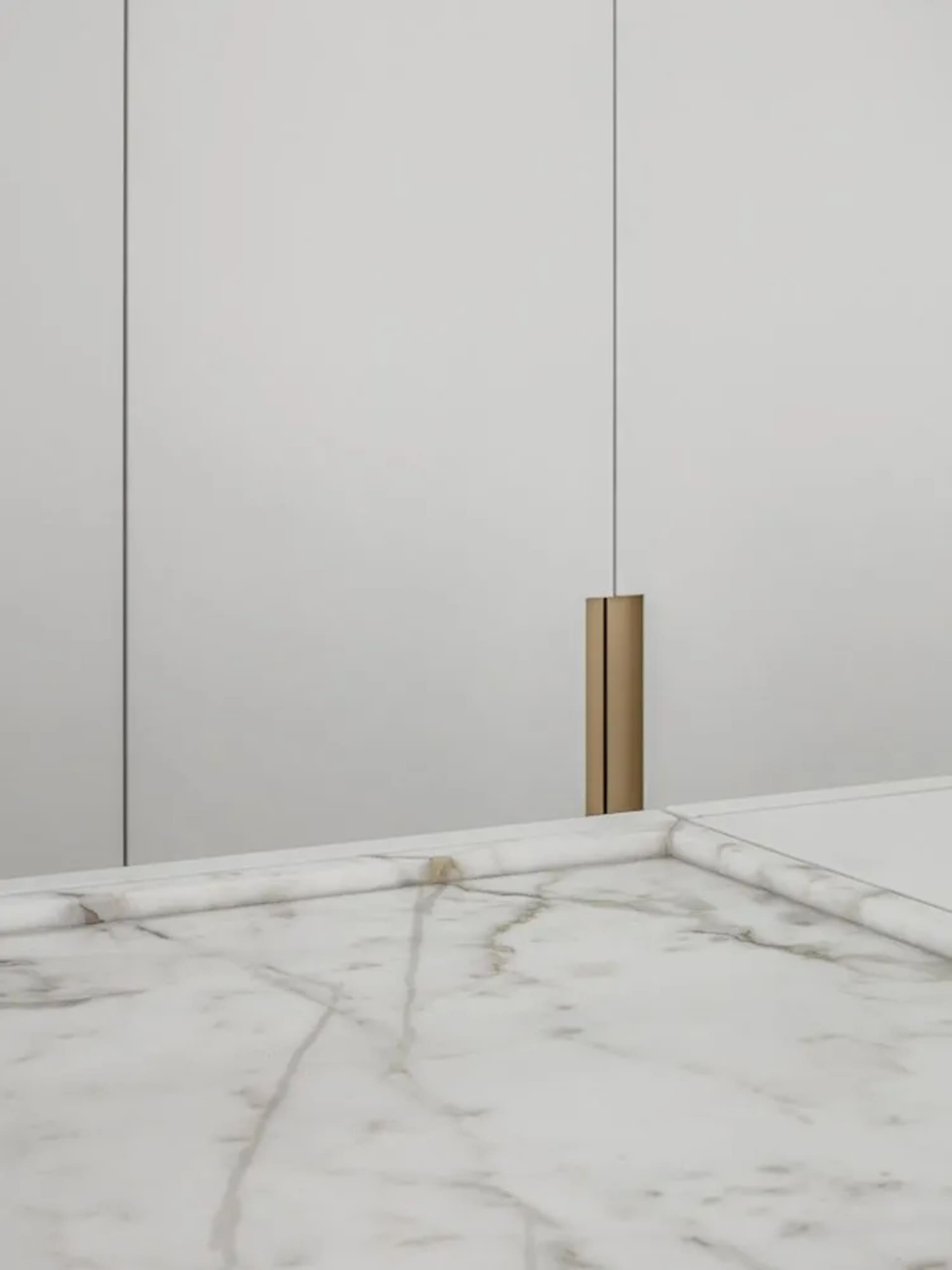 A minimalist modern interior design featuring marble surfaces with subtle gold accents.