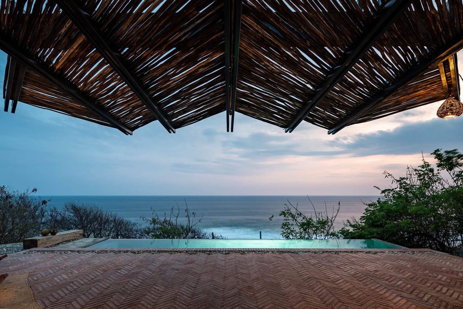 A wooden roof with a view of the ocean and tropical surroundings.