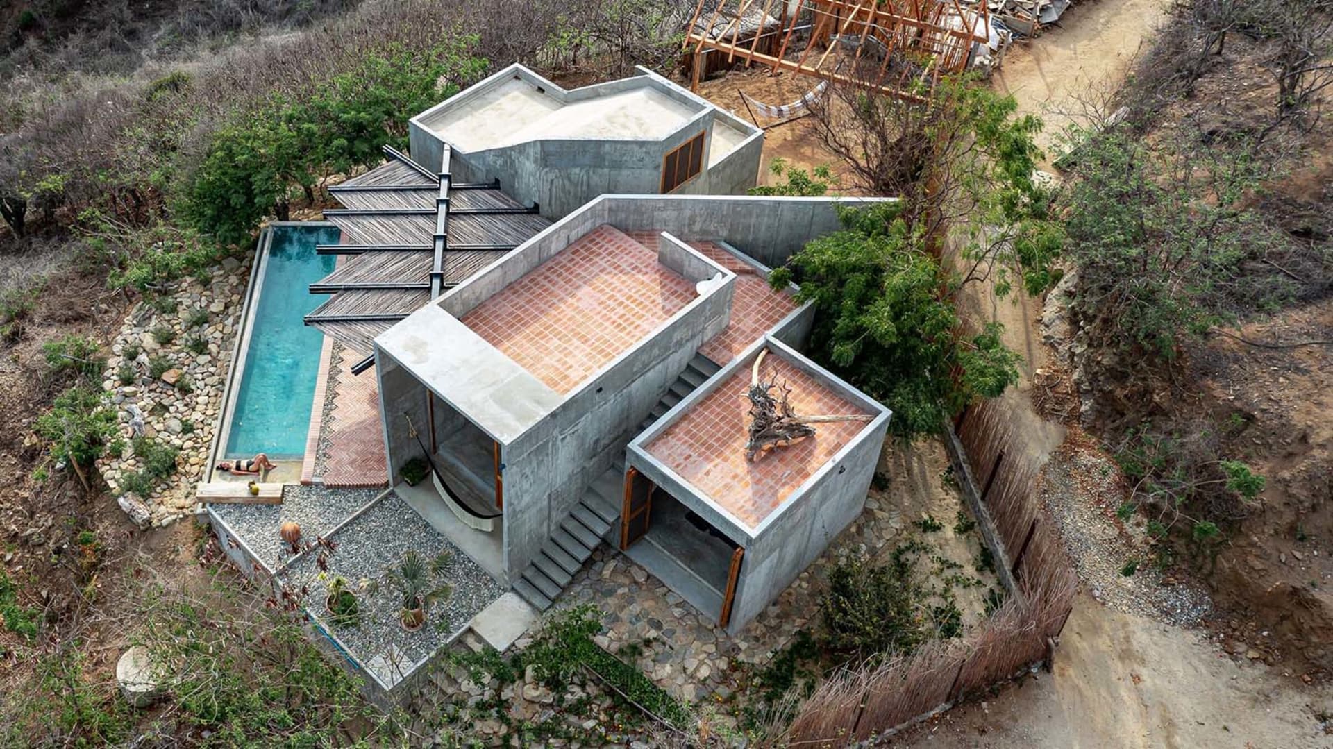 一座現代混凝土住宅,配有泳池和陶瓦屋頂。