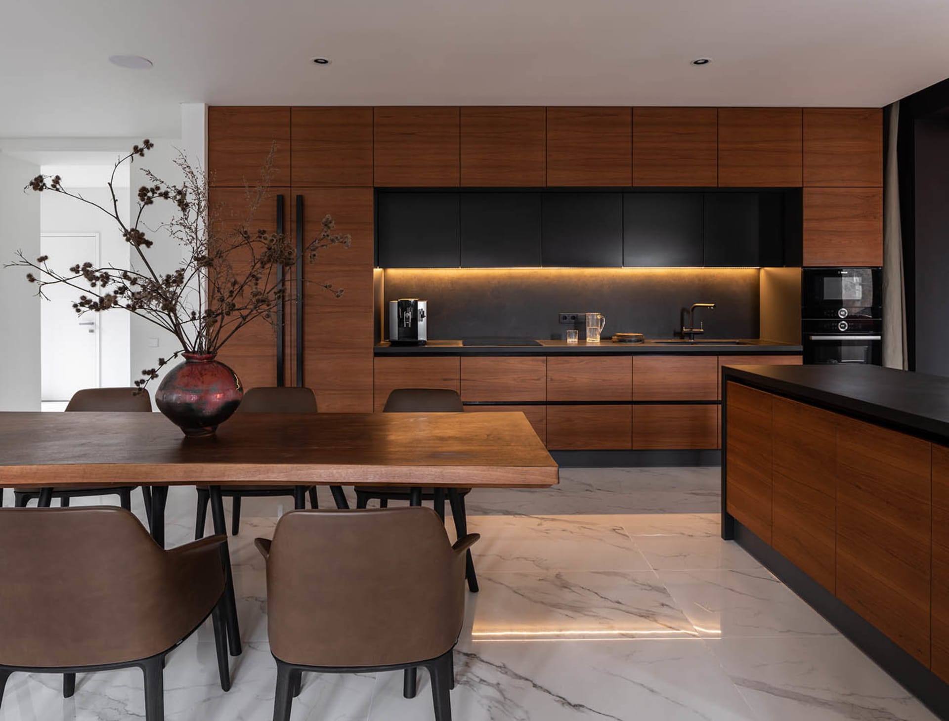 A modern residential kitchen featuring wood accents and marble countertops.