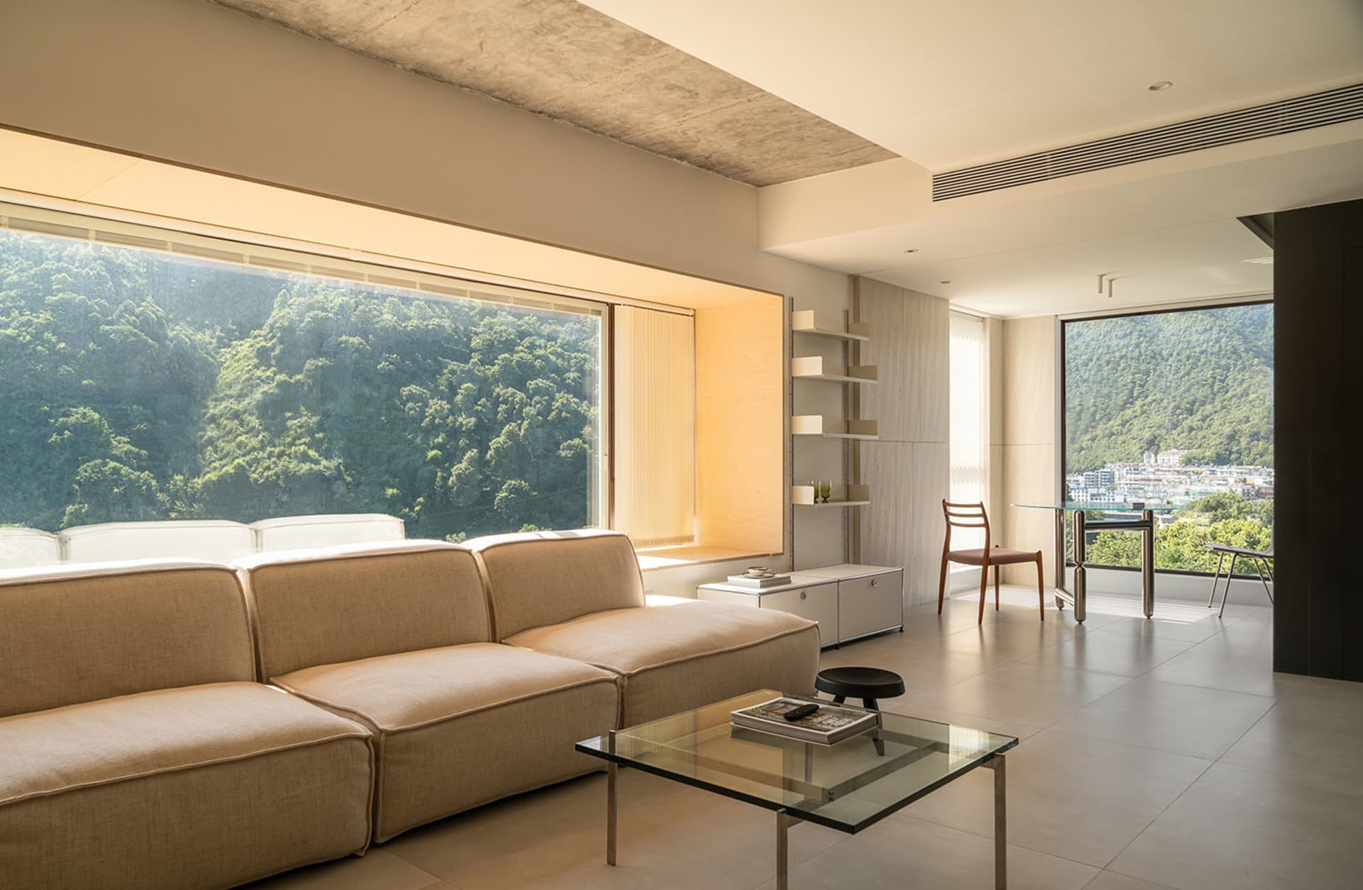Modern living room with concrete walls, floor, and furniture.