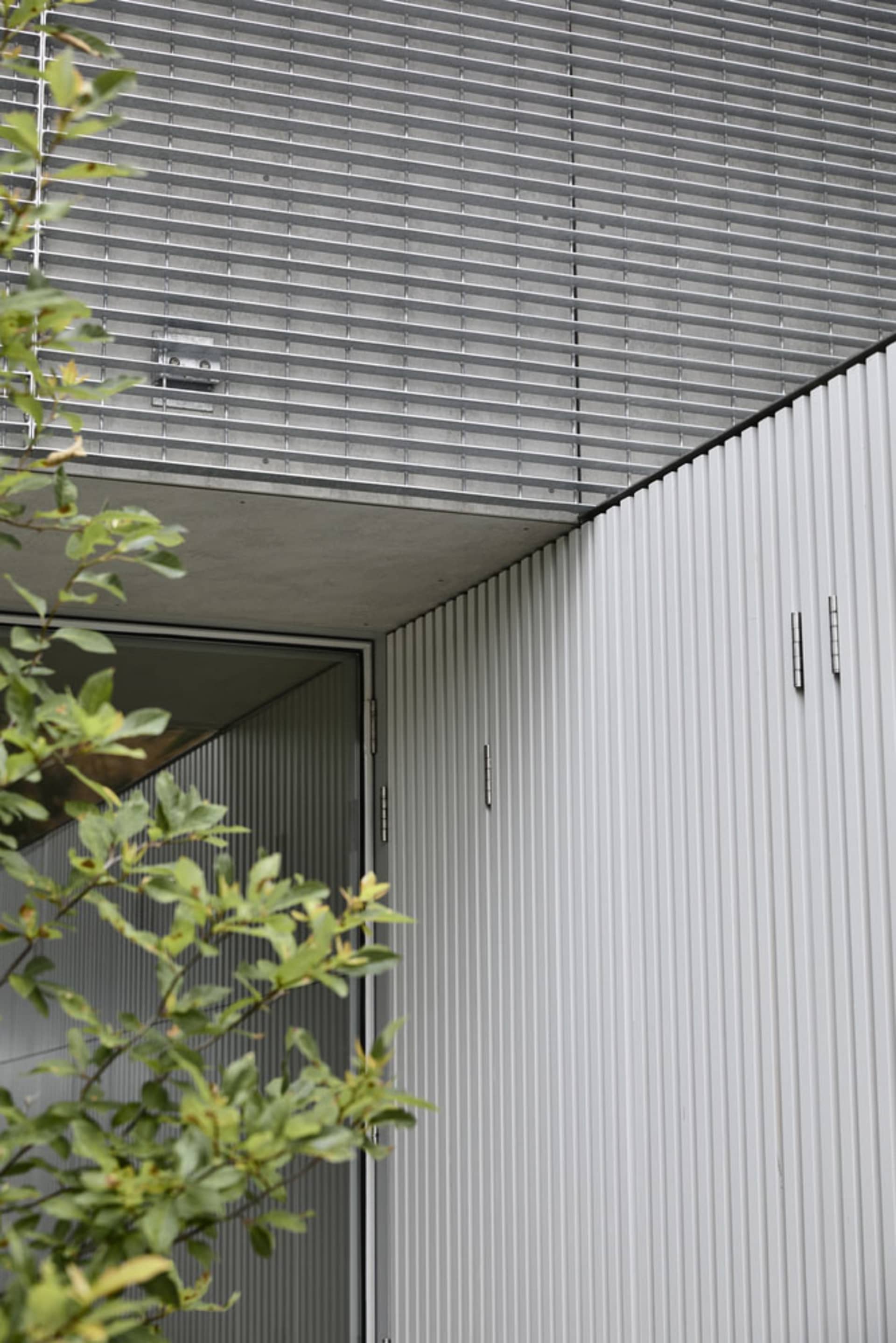 Modern house exterior featuring metal cladding and concrete materials