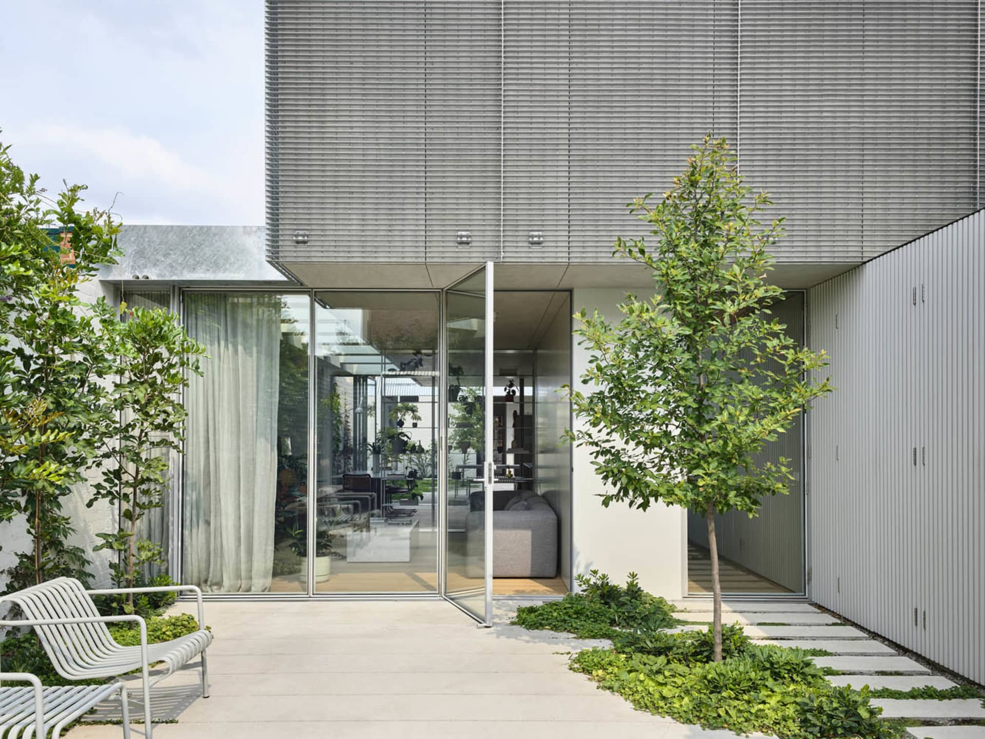 Minimalist residential architecture featuring a modern design with metal, glass, and concrete elements.