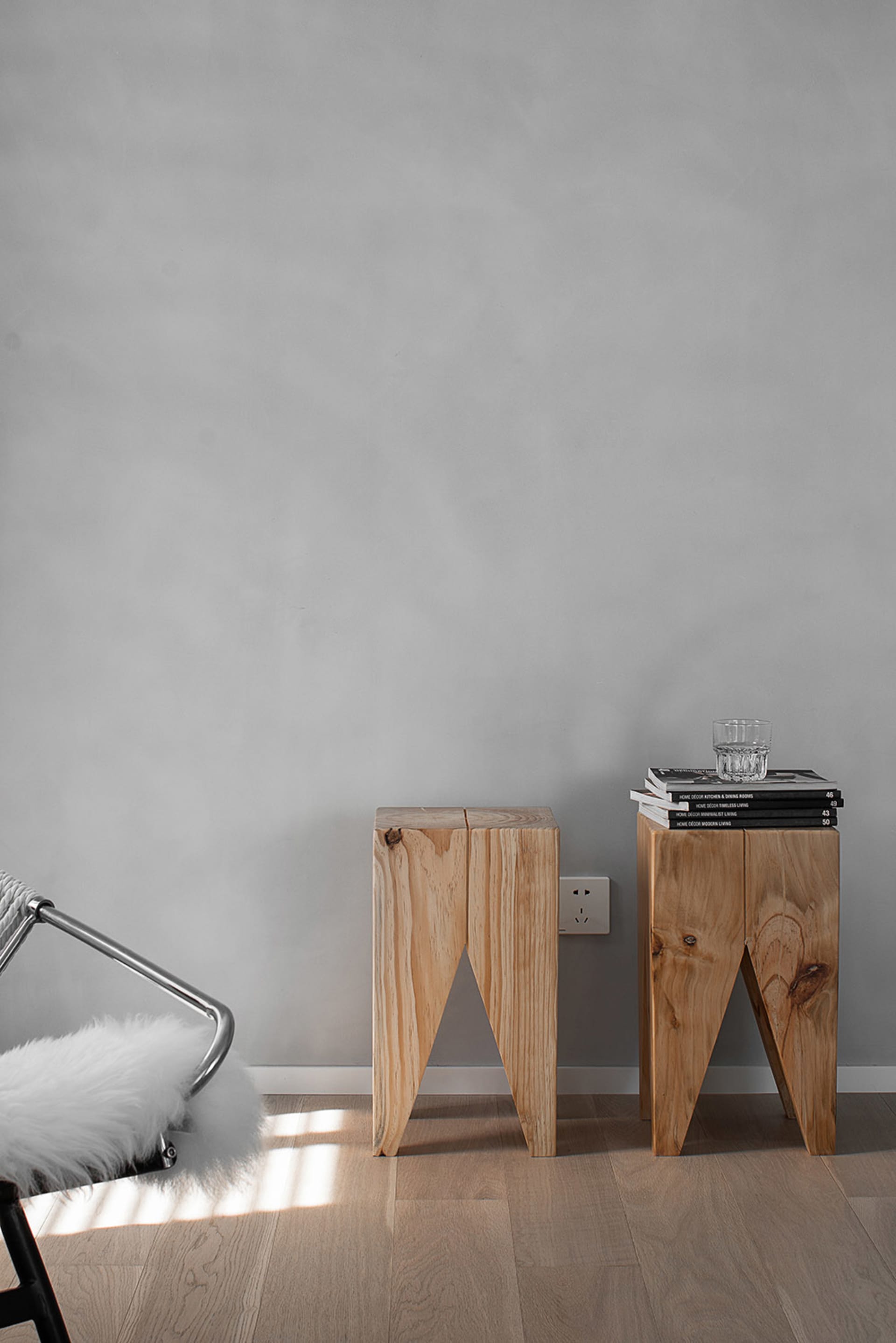 Two modern Scandinavian side tables made of light-colored wood in a living room setting.