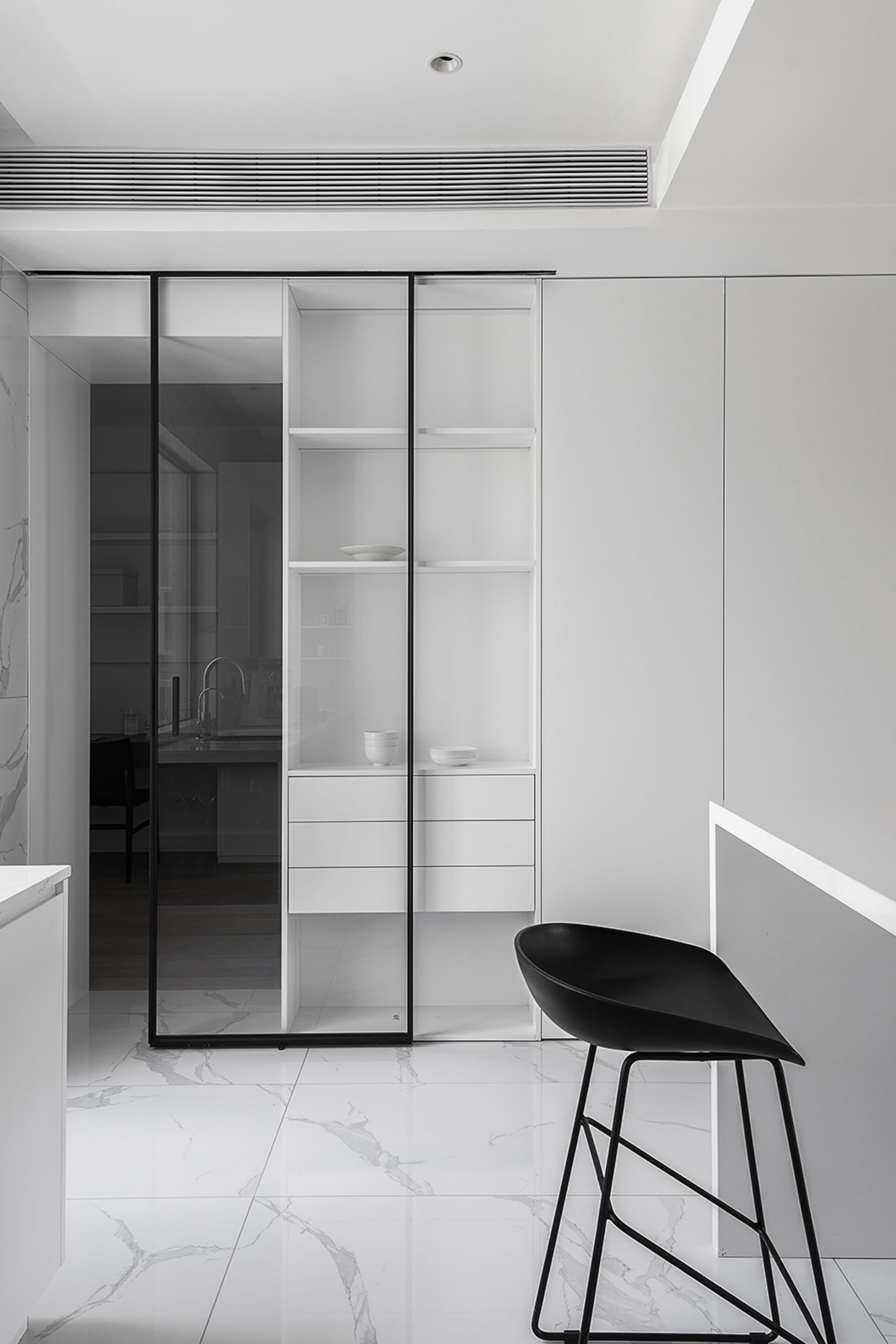 Modern minimalist kitchen featuring white marble countertops and metal accents