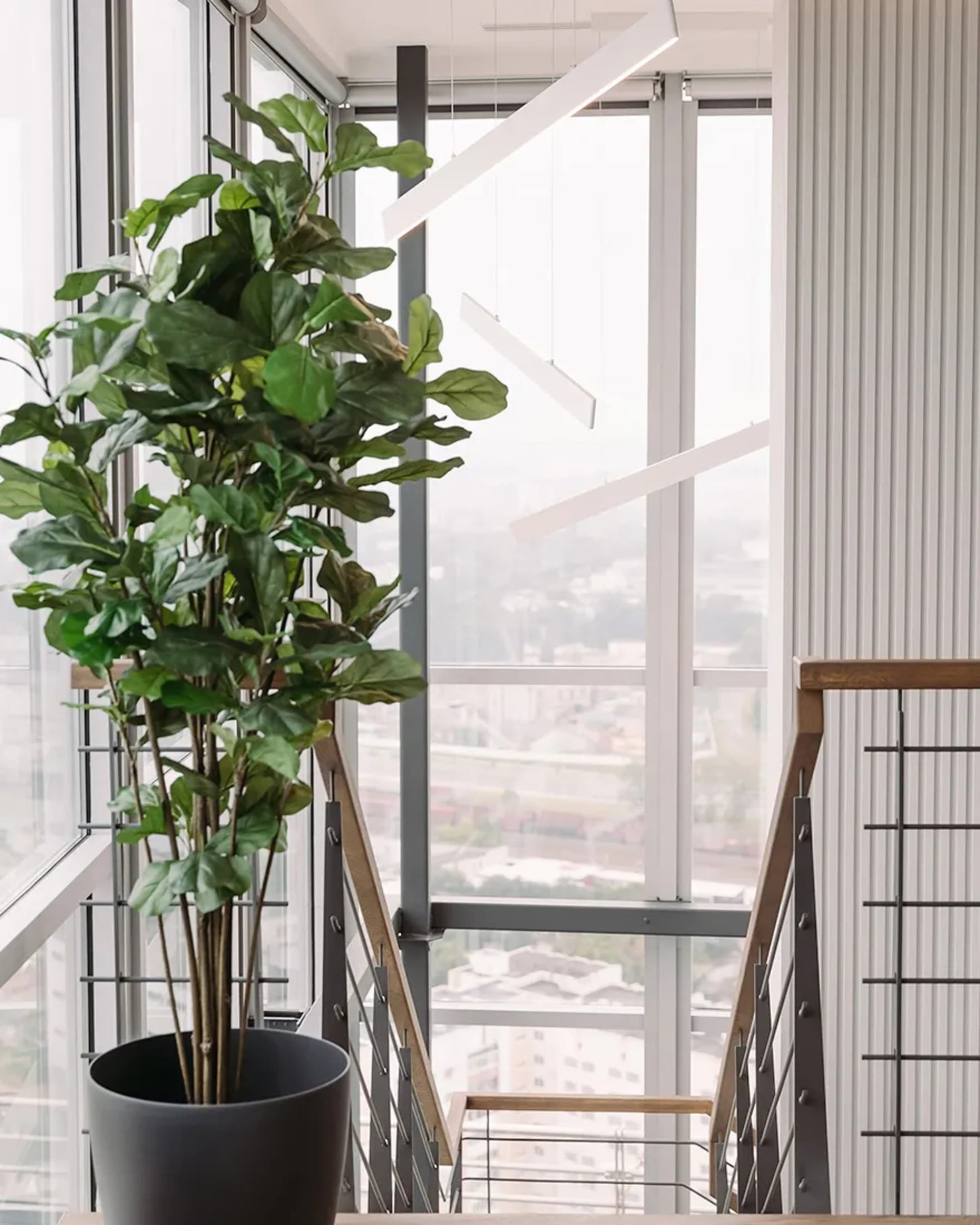 A modern office space featuring glass, metal, and wood elements.