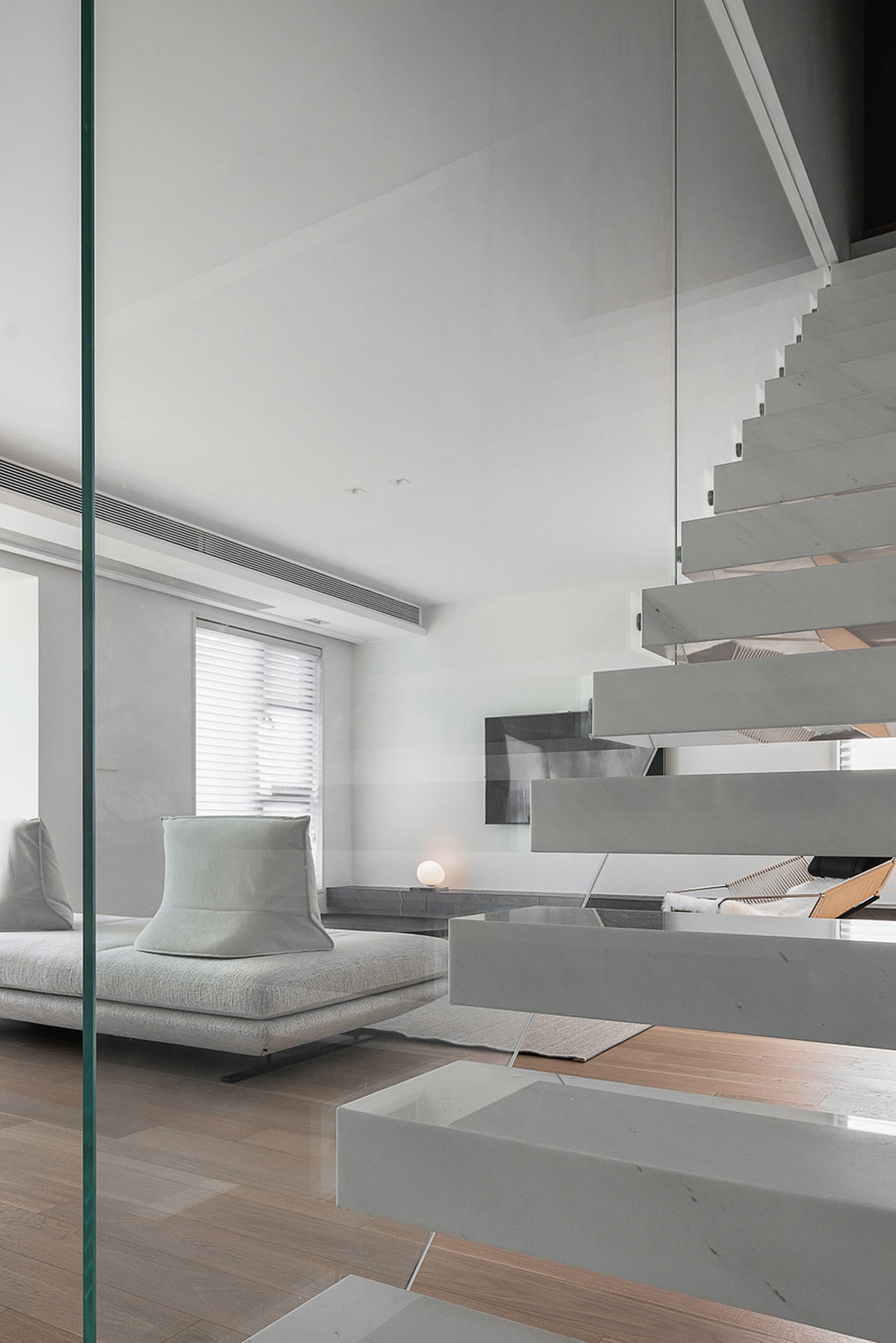 Modern living room with concrete stairs and minimalist furniture.