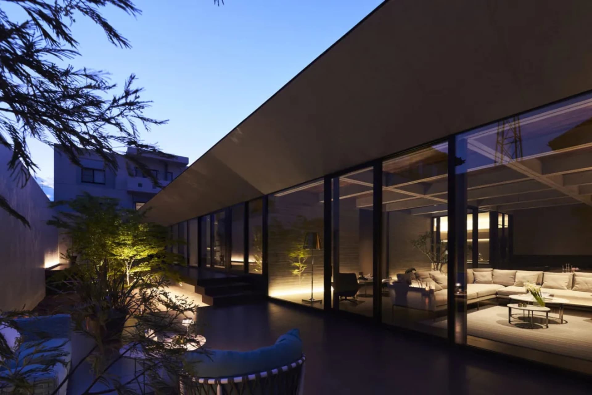 Modern living room featuring glass walls and concrete floors