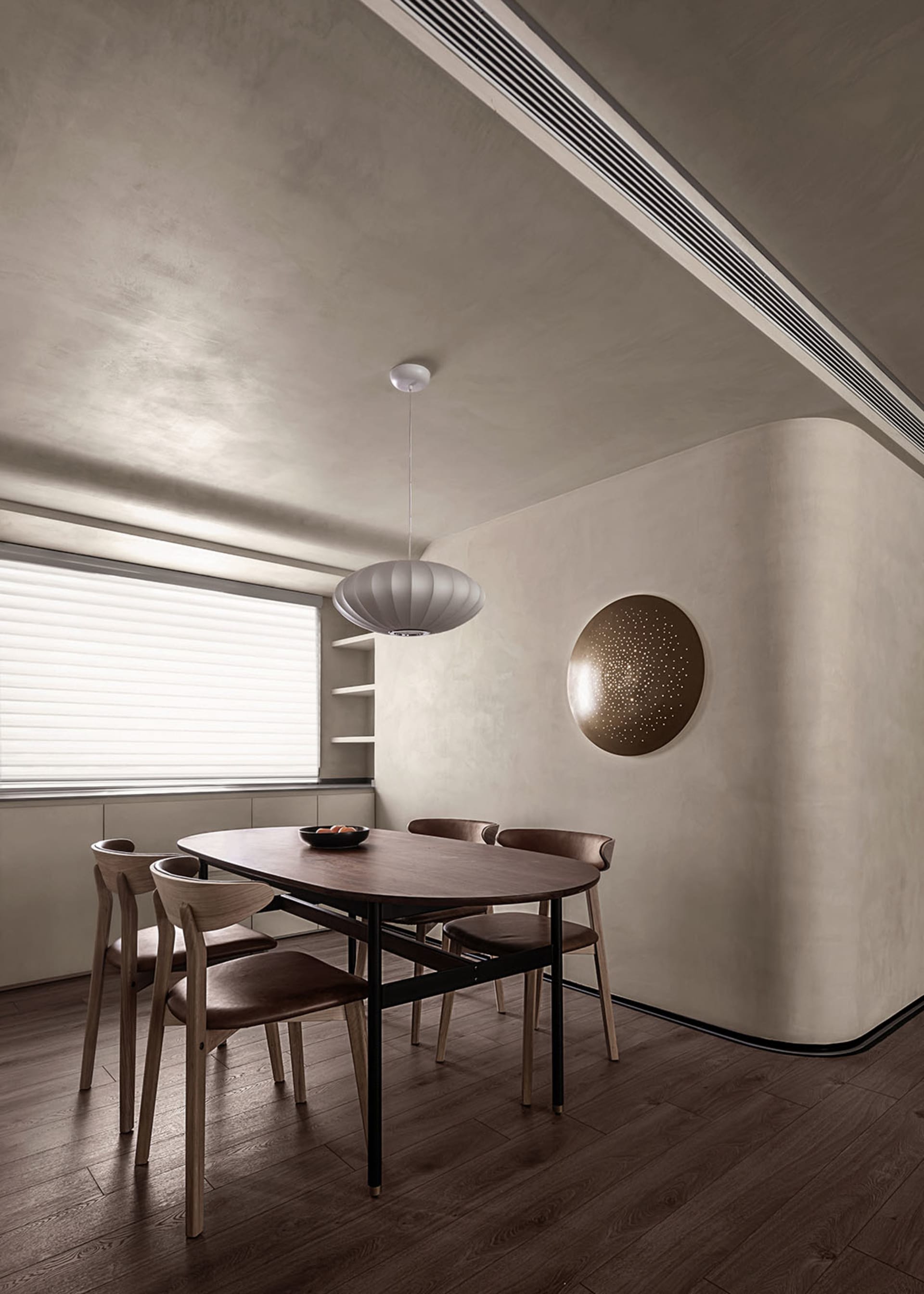 A modern dining room featuring wooden flooring, a wooden dining table with black legs, wooden chairs with brown cushions, a r