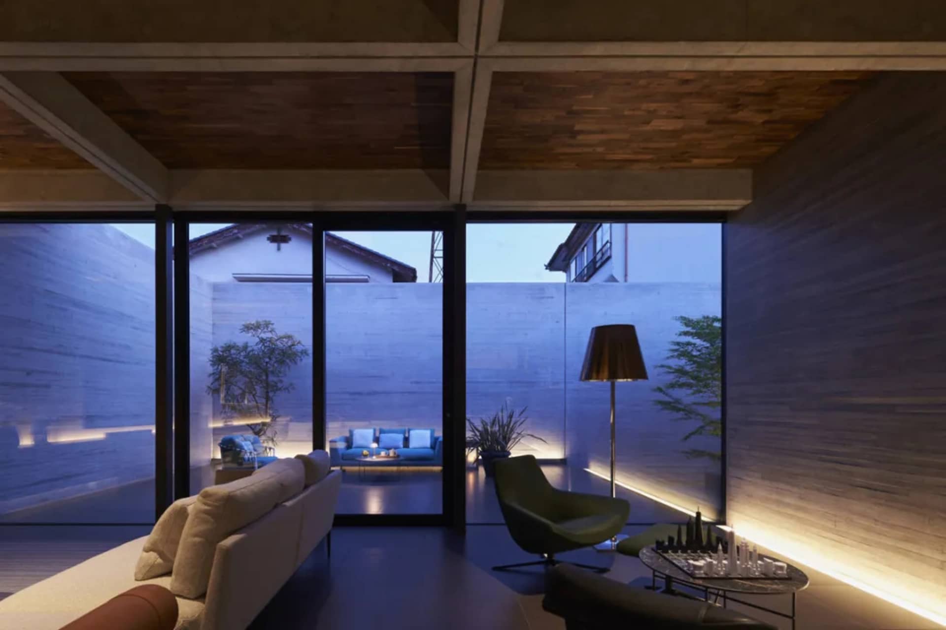 A modern living room featuring concrete walls and furniture with a minimalist design.