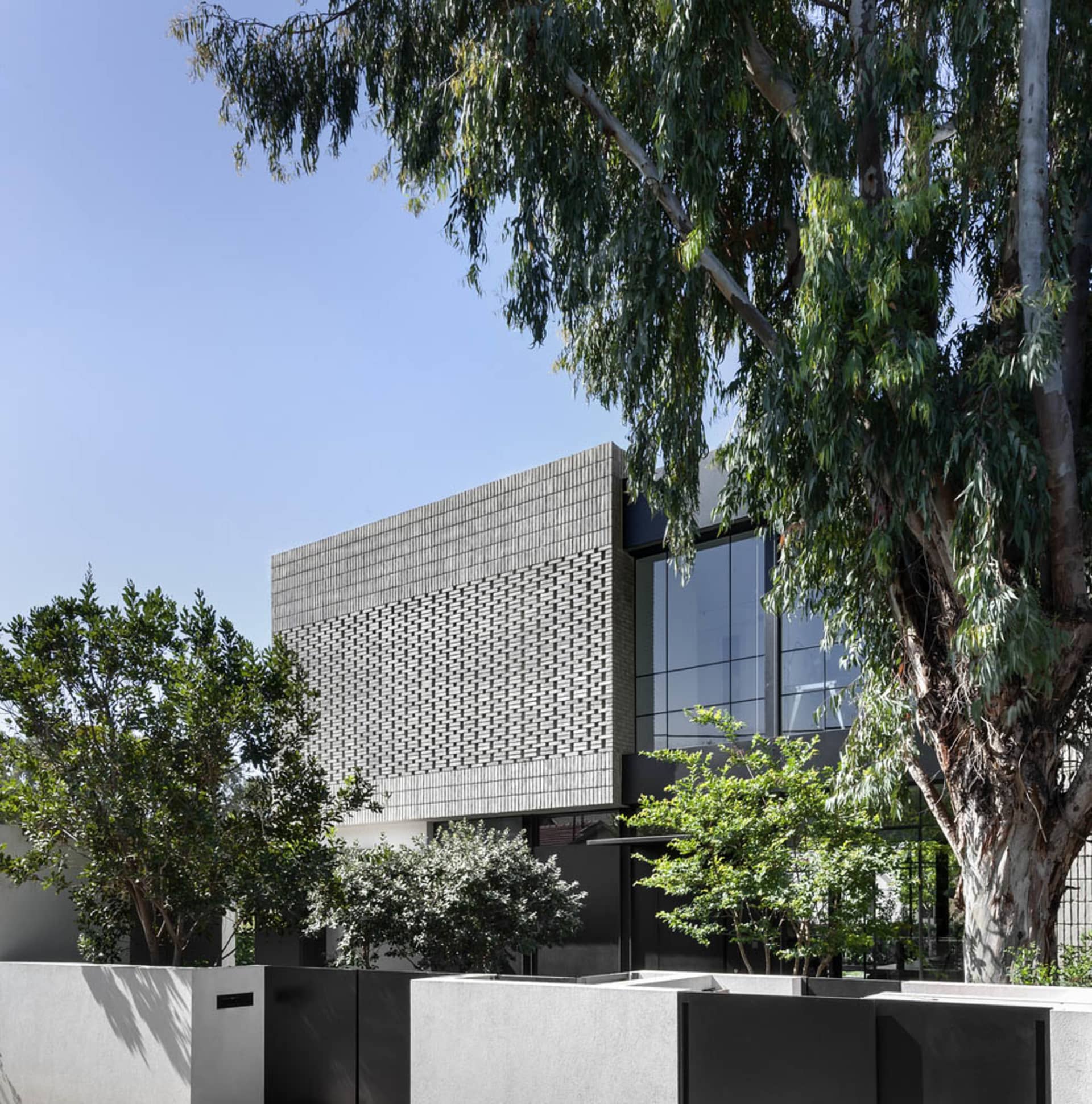 A modern house featuring glass walls in a peaceful outdoor setting.