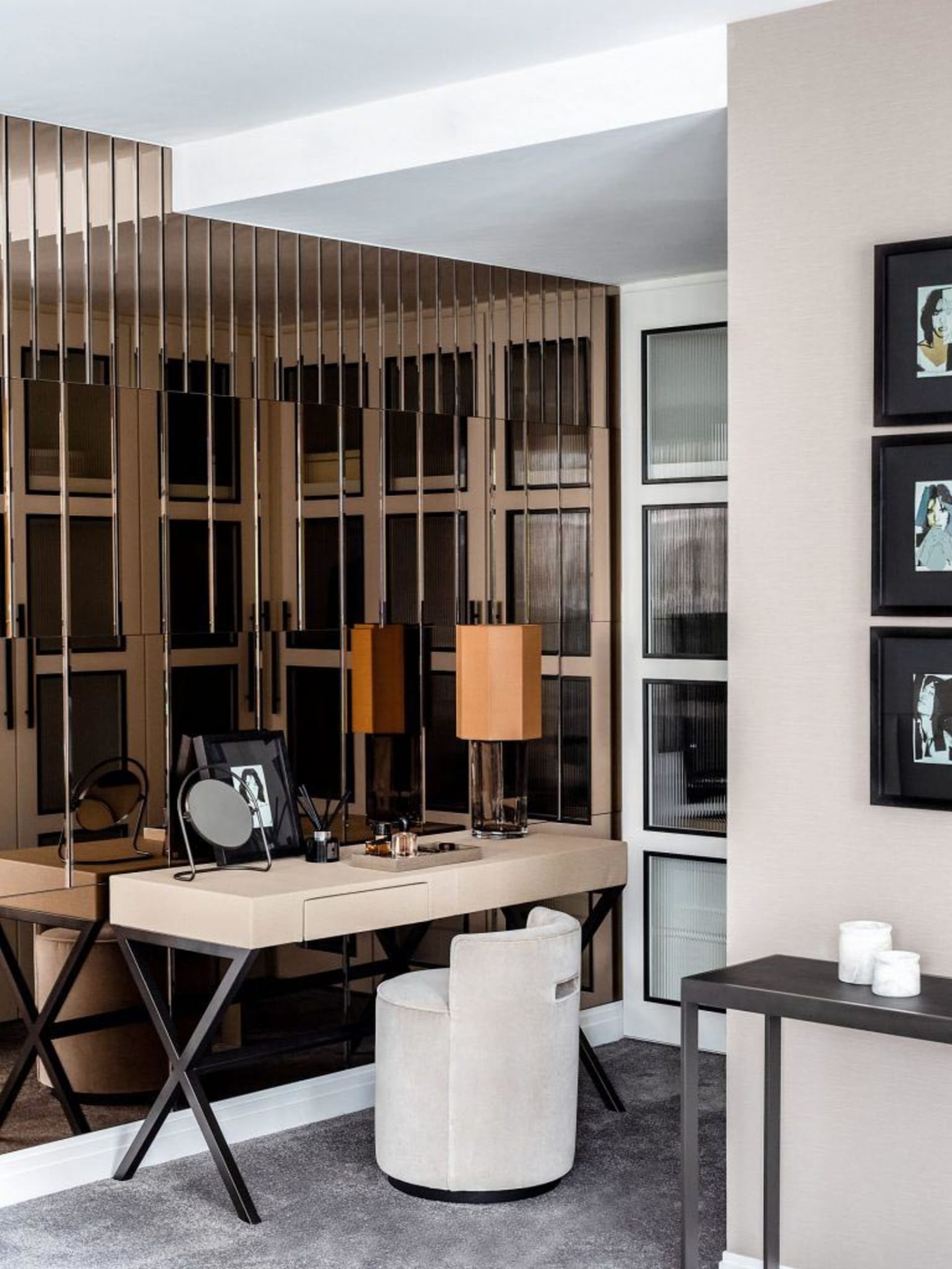 A modern home office featuring a sleek desk, round chair, and decorative elements.