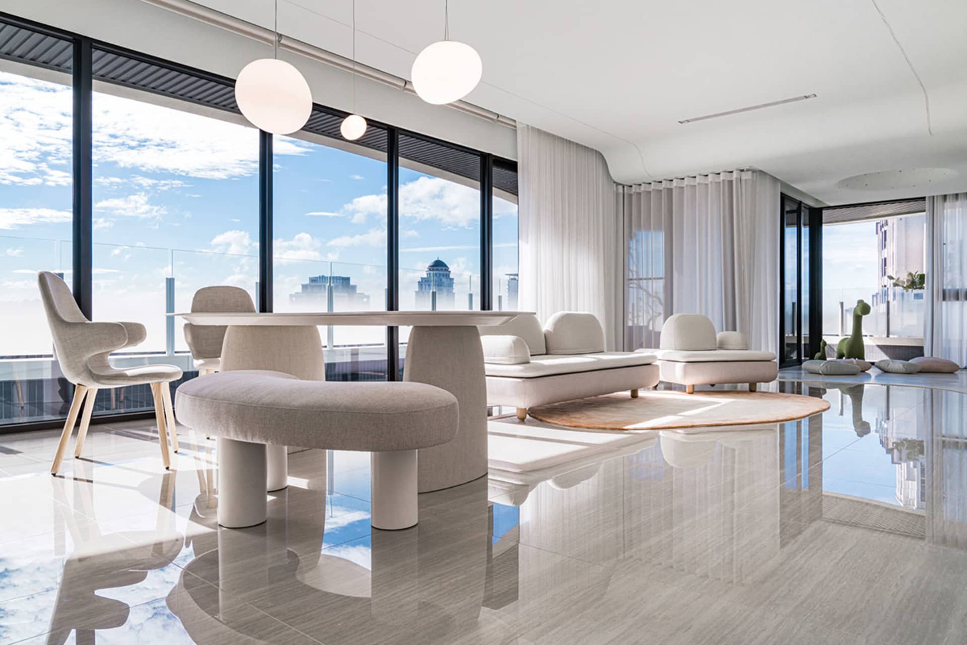 Modern living room featuring a light gray marble floor, minimalist furniture, and large windows with a cityscape view.