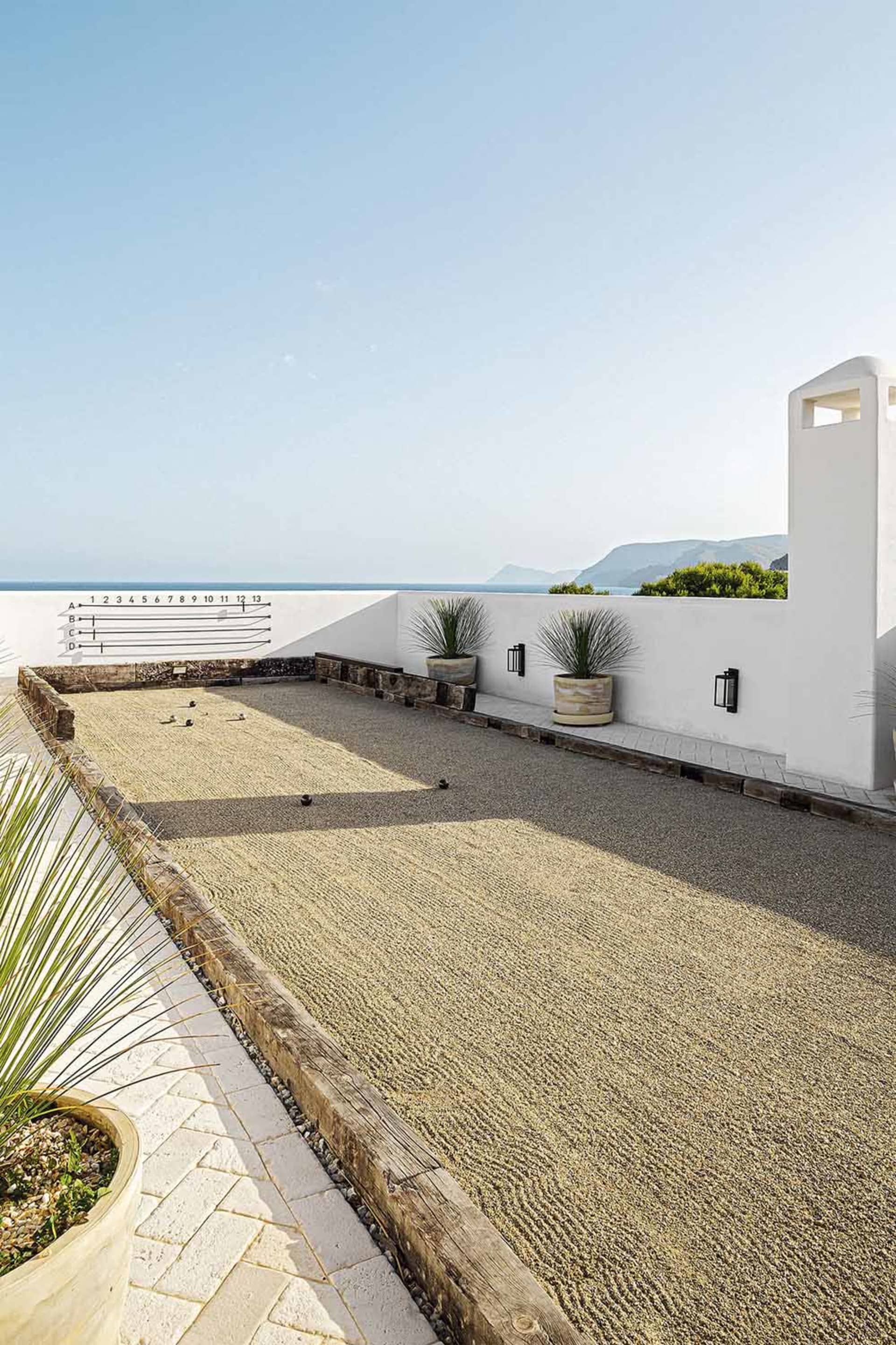 Outdoor residential space with a modern design, featuring a concrete floor and minimalist decor.