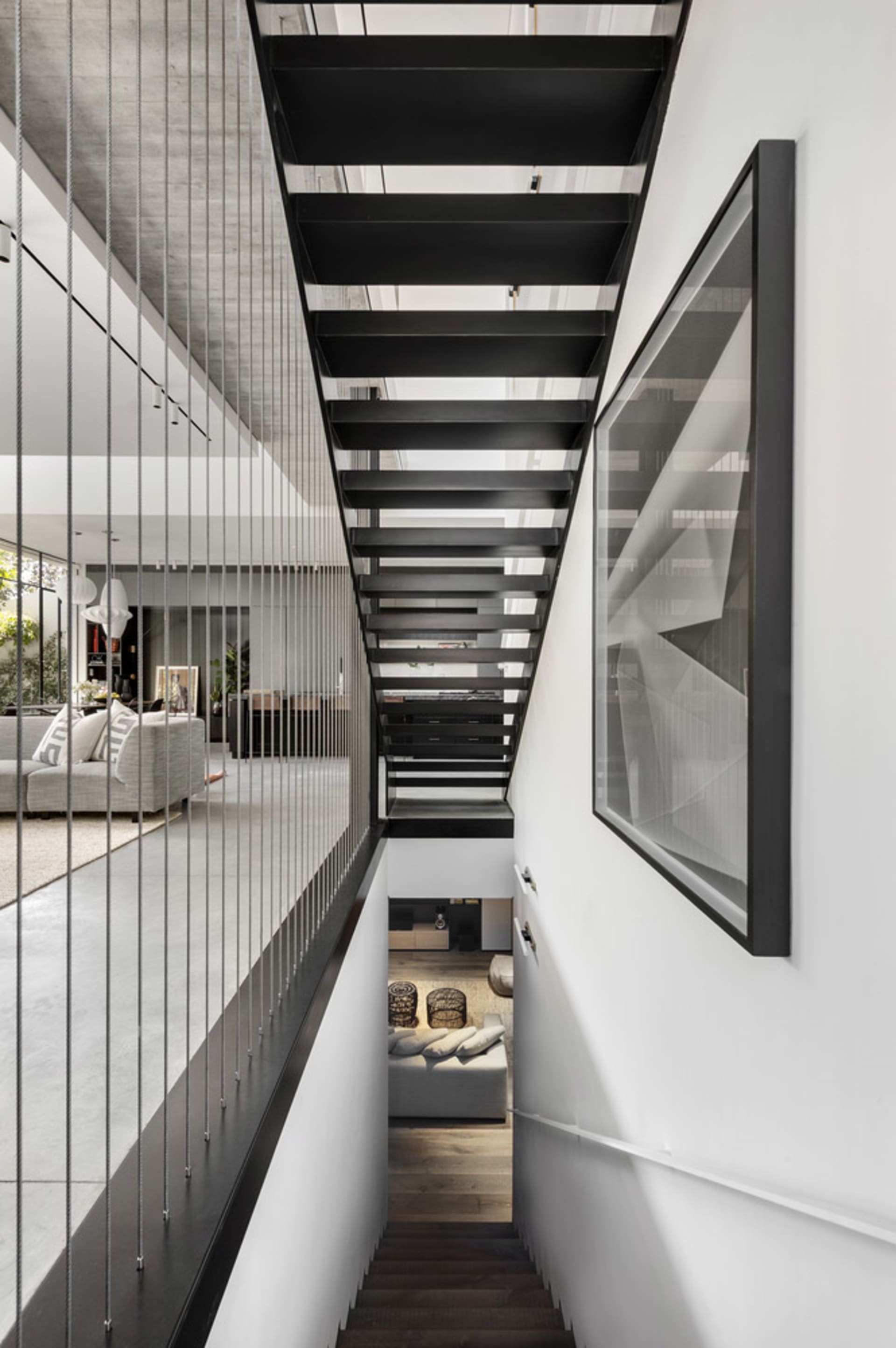 A modern residential staircase featuring black metal treads and railings.