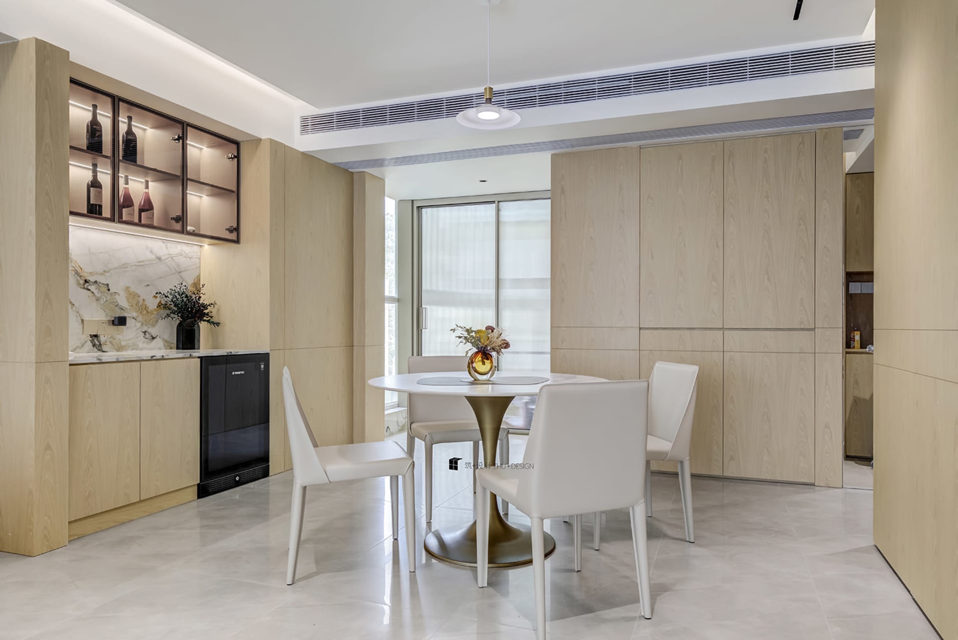 Modern kitchen and dining area with marble countertops and wooden cabinetry.